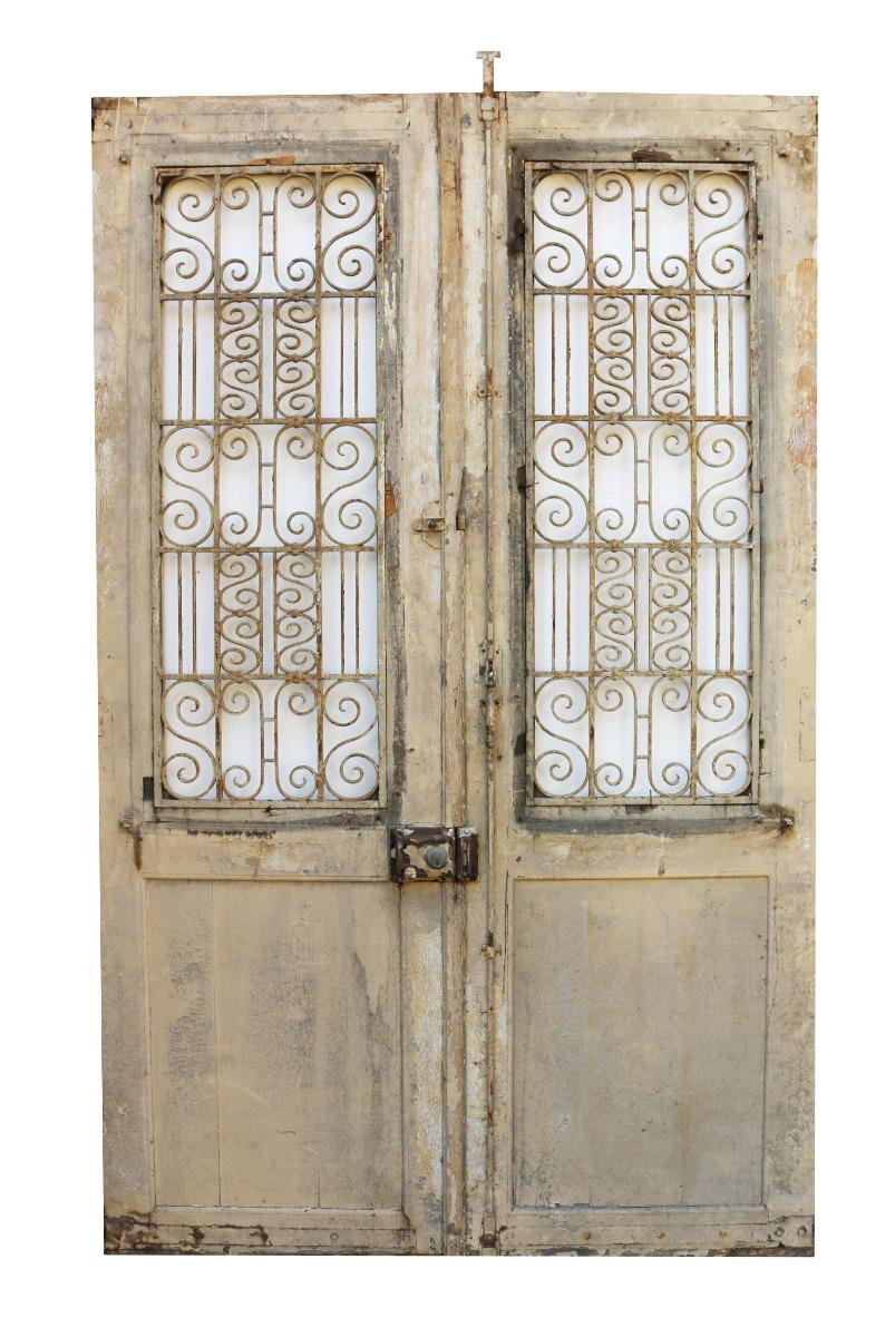 These salvaged doors are constructed from oak. They are fitted with scrolling iron panels.