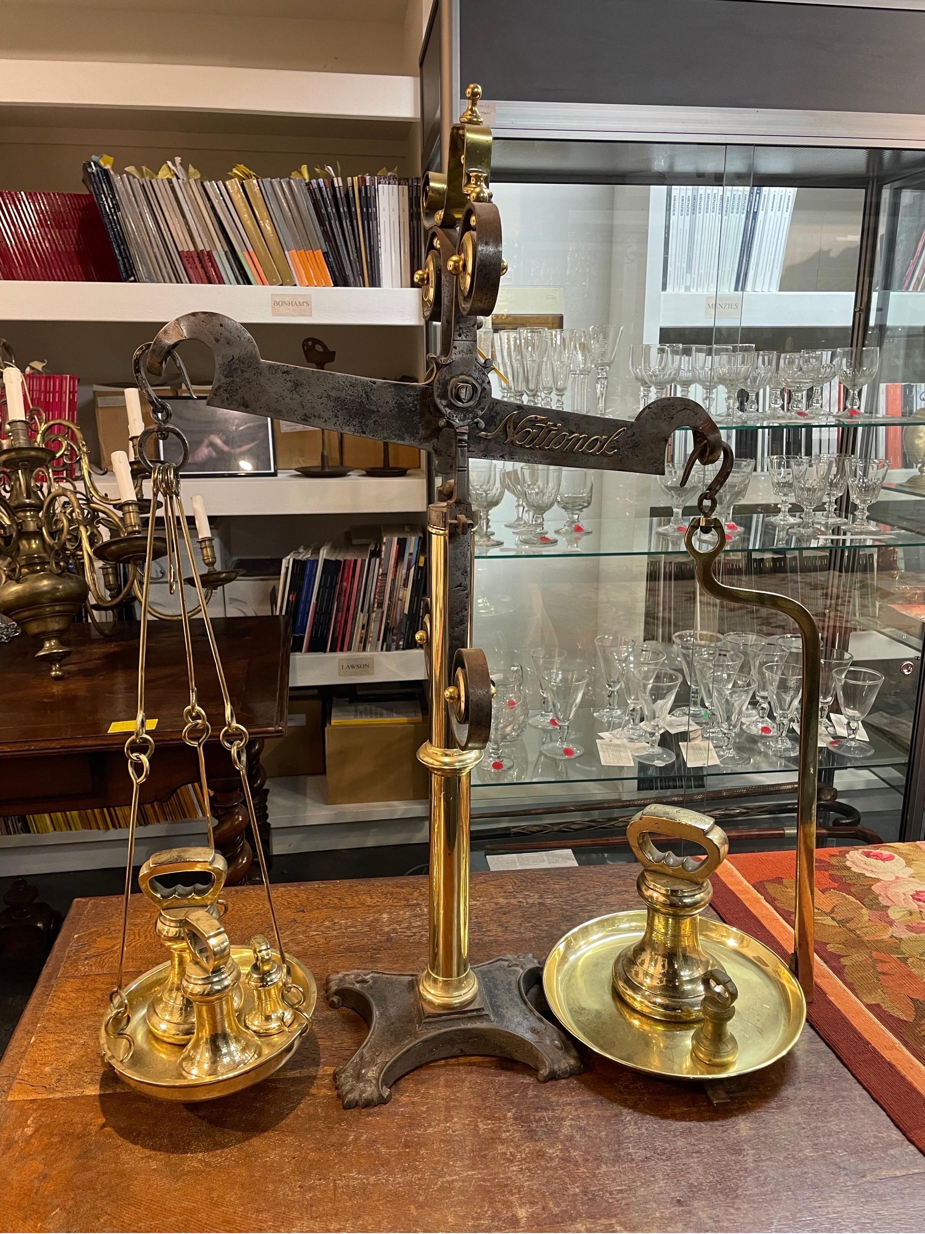 A Set of Antique English Brass and Steel Balance Beam Scales, Made by National, 19th/20 century
with a series of five brass bell weights, the heaviest 11 pounds

Height: 89 cm Width: 72cm Depth: 30cm

Provenance: Private Australian Collection