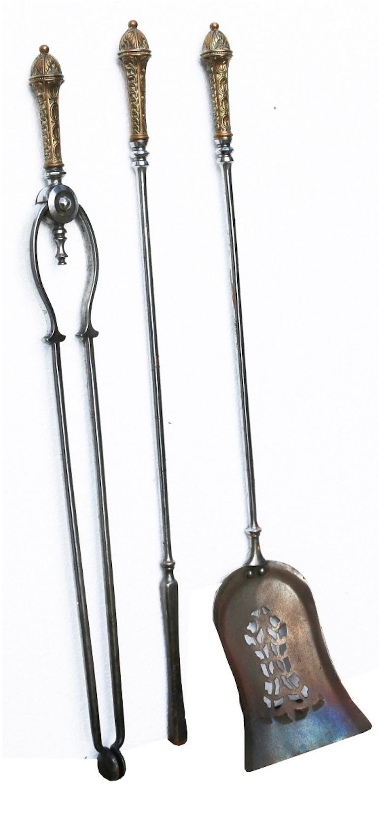 Consisting of tongs, poker and a pierced shovel, each having a brass handle.