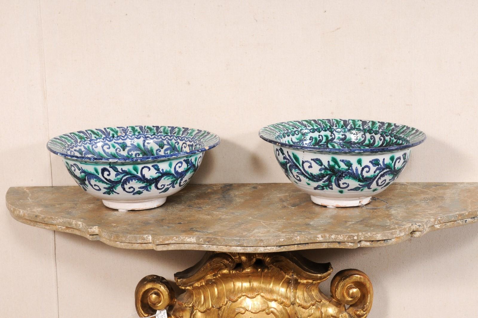 Paire de bols espagnols en céramique peints à la main, datant du début du 20e siècle. Ces bols anciens d'Espagne sont de forme ronde, la partie la plus large se situant au niveau de la lèvre supérieure, et s'amenuisant progressivement pour reposer