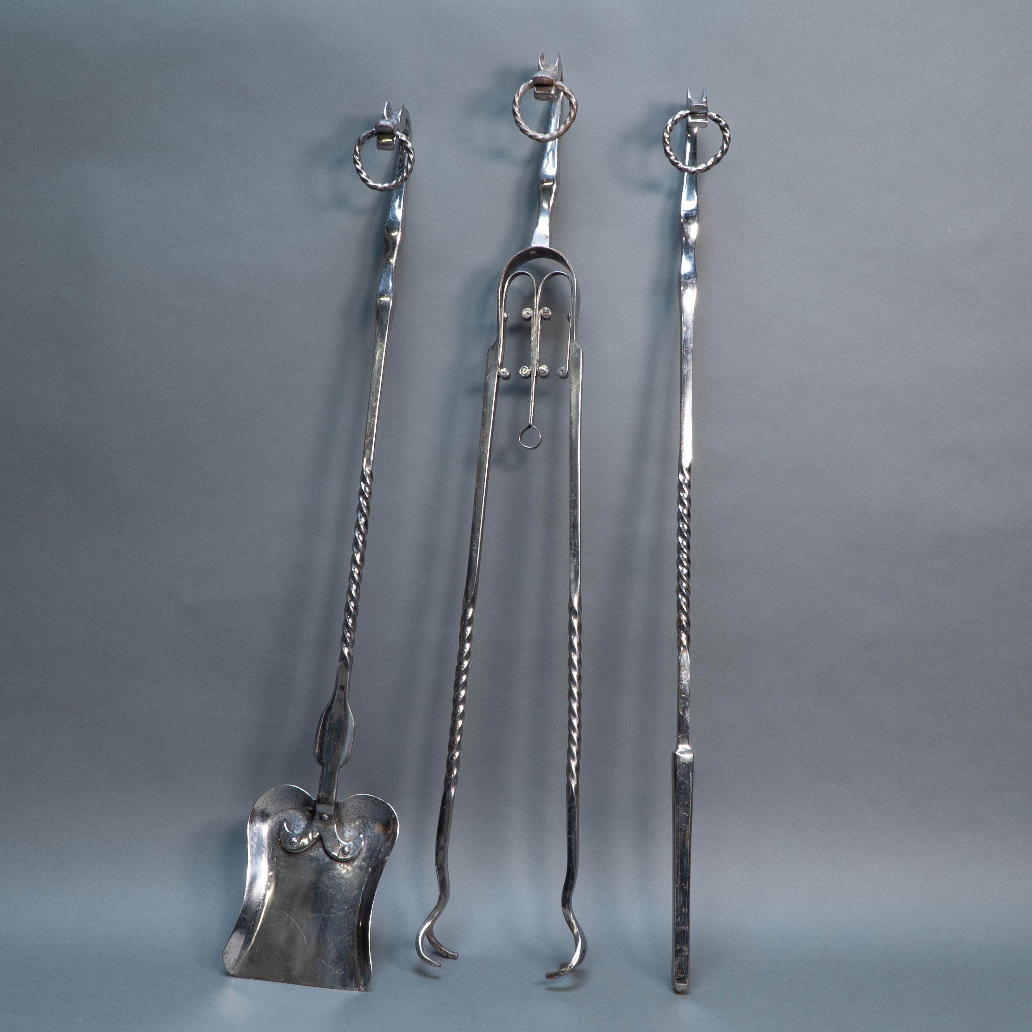 Eine Reihe von Arts and Crafts Cotswold School poliertem Stahl handgeschmiedet Feuer Utensilien mit stilisierten Hunden oder Drachenköpfe mit gedrehten Ringen zu hängen, und writhern Stielen.
Abmessungen:
Poker - Höhe: 84.5cm / 34.65 Inches , Breite