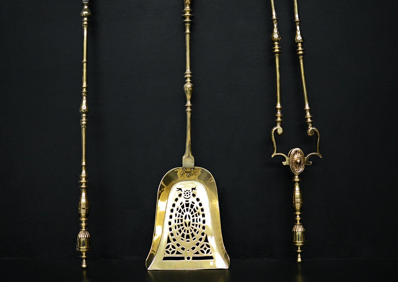 A set of decorative brass firetools. The uprights with swells, surmounted by gadrooned urn finiais. Pierced, shaped pan. English, late Regency/early Victorian. 

Length:	745 mm      	29 ⅜