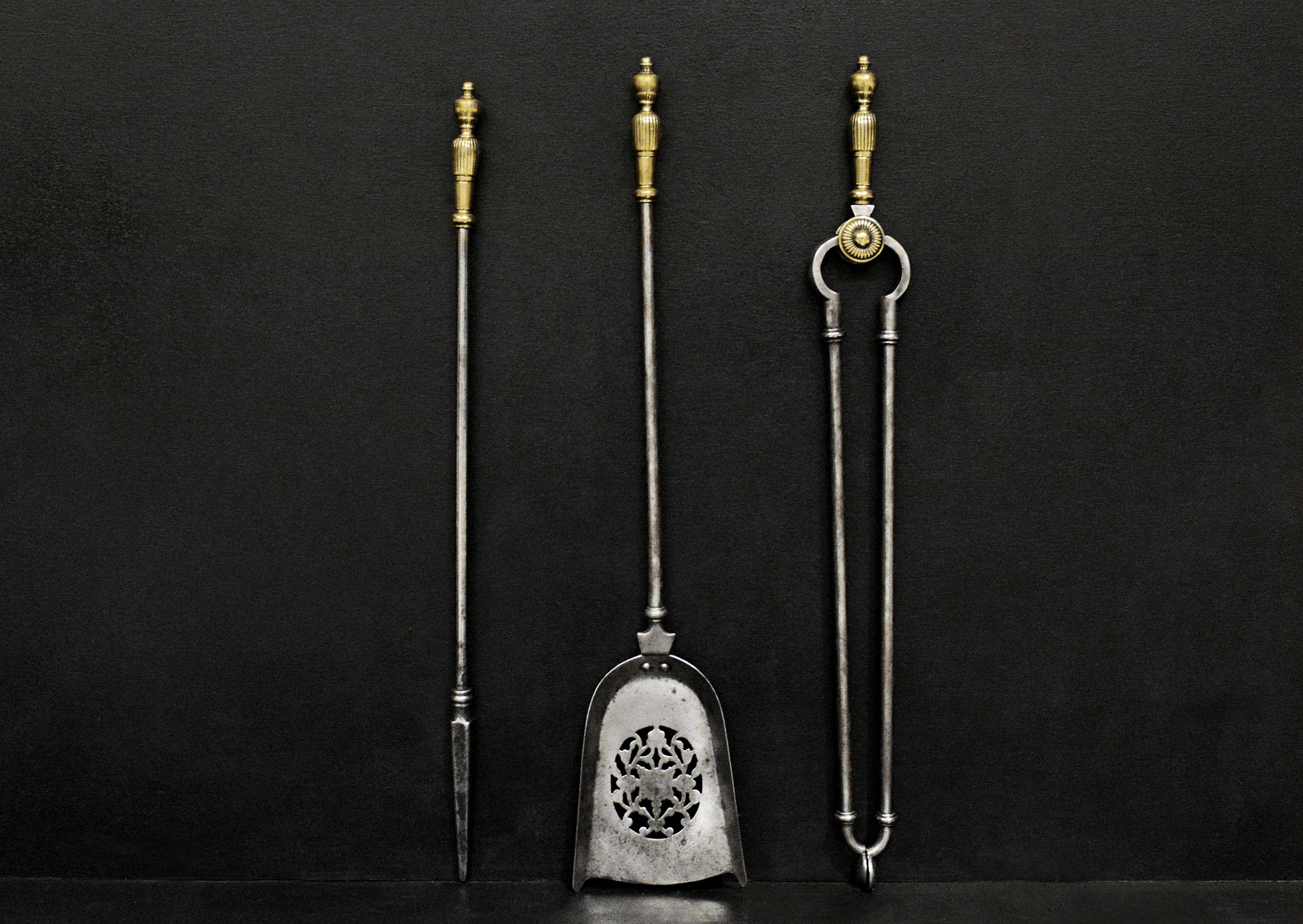 A set of brass and steel firetools in the Georgian style. The gadrooned brass handles. The tongs with gadrooned patera, the shovel with pierced pan. English, 19th century.

Length:	785 mm      	30 ⅞
