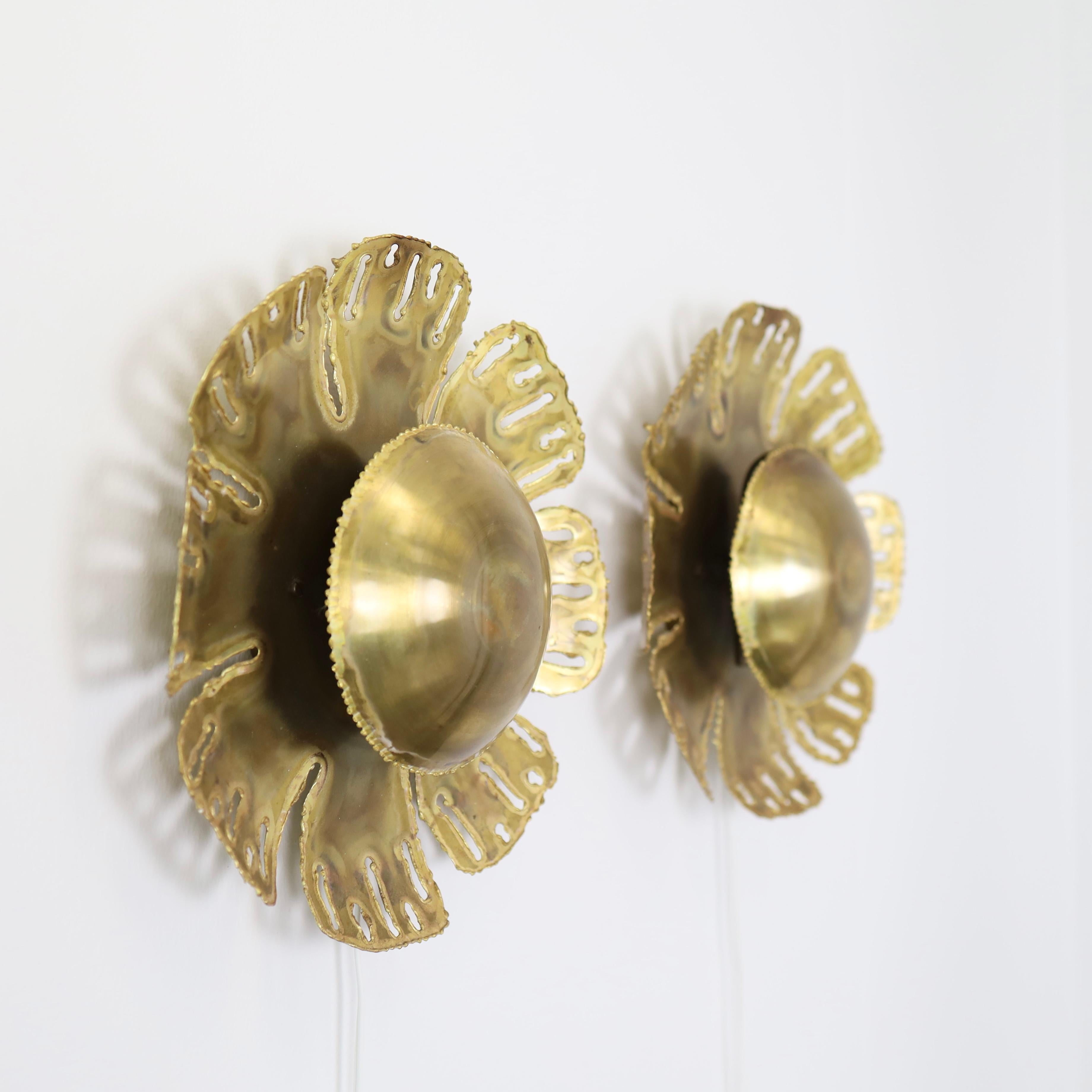 A set of sun-shaped brass wall lamps designed by Svend Aage Holm Sørensen in the 1960s. This eye-catching design is a trademark of the Danish designer. 

* A set (2) of sunflower shaped brass wall sconces
* Designer: Svend Aage Holm Sørensen
*