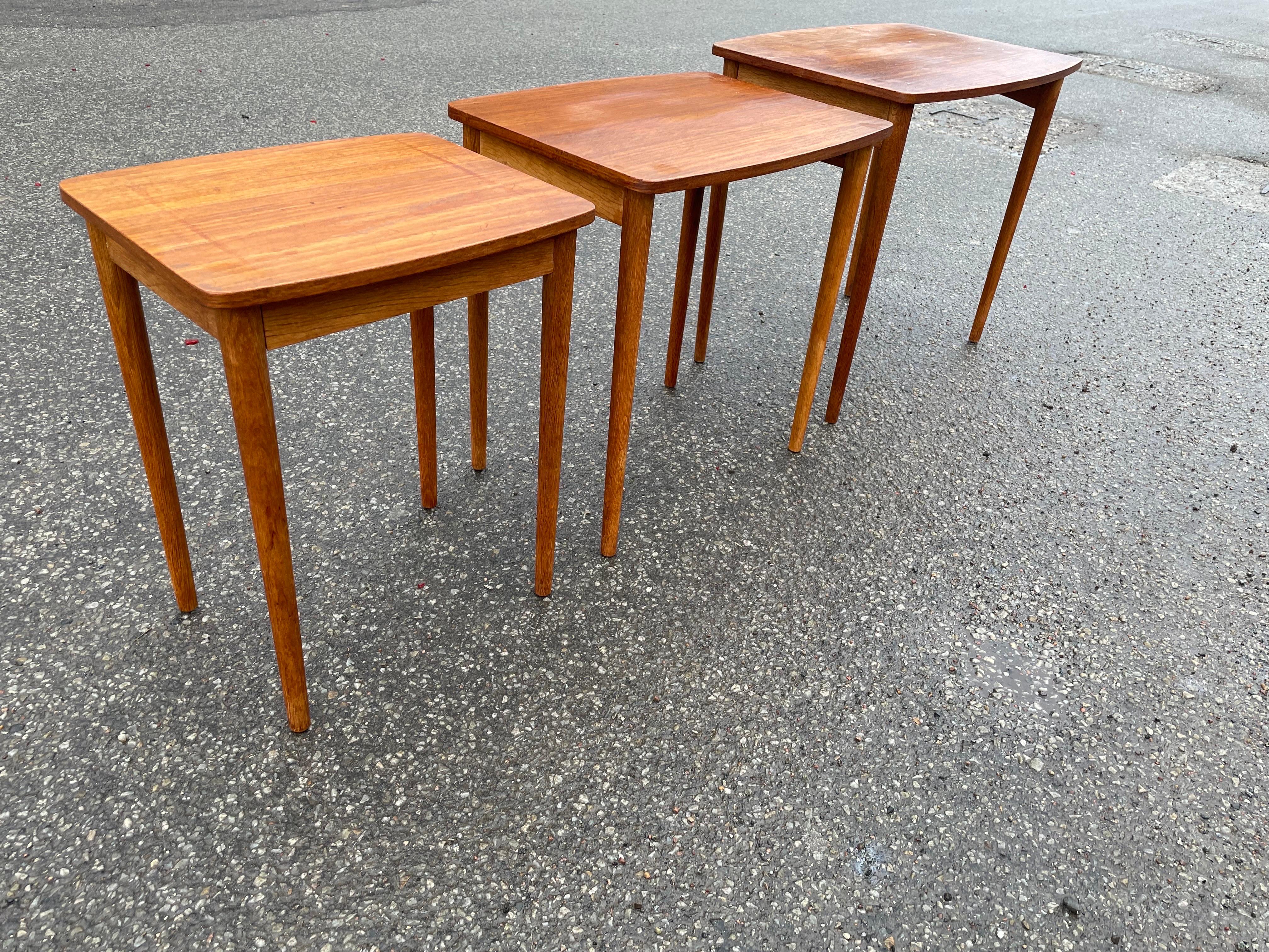 This set of teak nesting tables from the 1960s is the perfect addition to any mid-century modern enthusiast's home. The nested design allows for easy storage when not in use, while the high-quality teak wood construction ensures durability and a