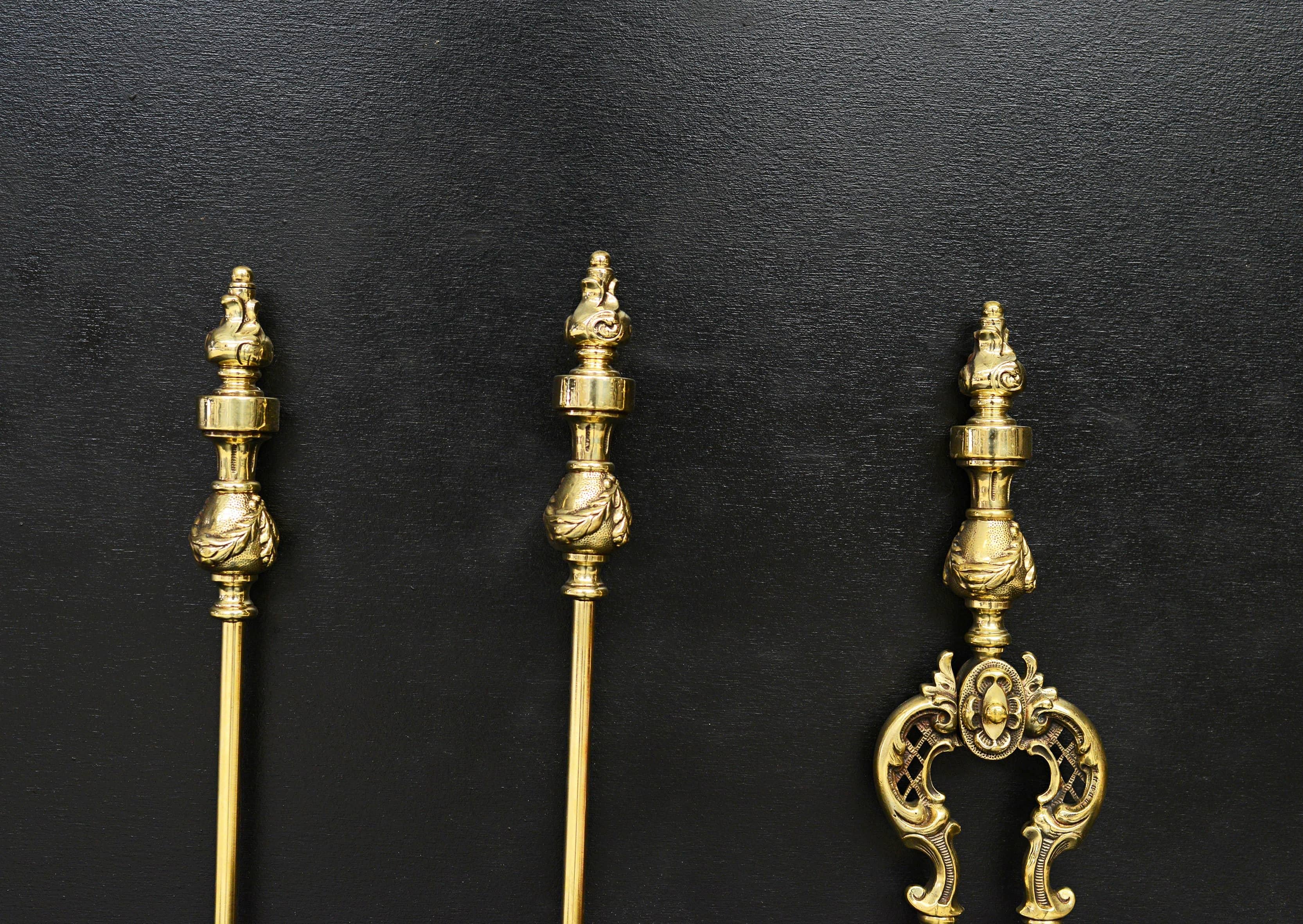 A set of decorative polished brass Victorian firetools. The cast brass handles with flame finials and drapery below, the shovel with decorative pan. English, mid 19th century. 

Measure: length: 710 mm 28