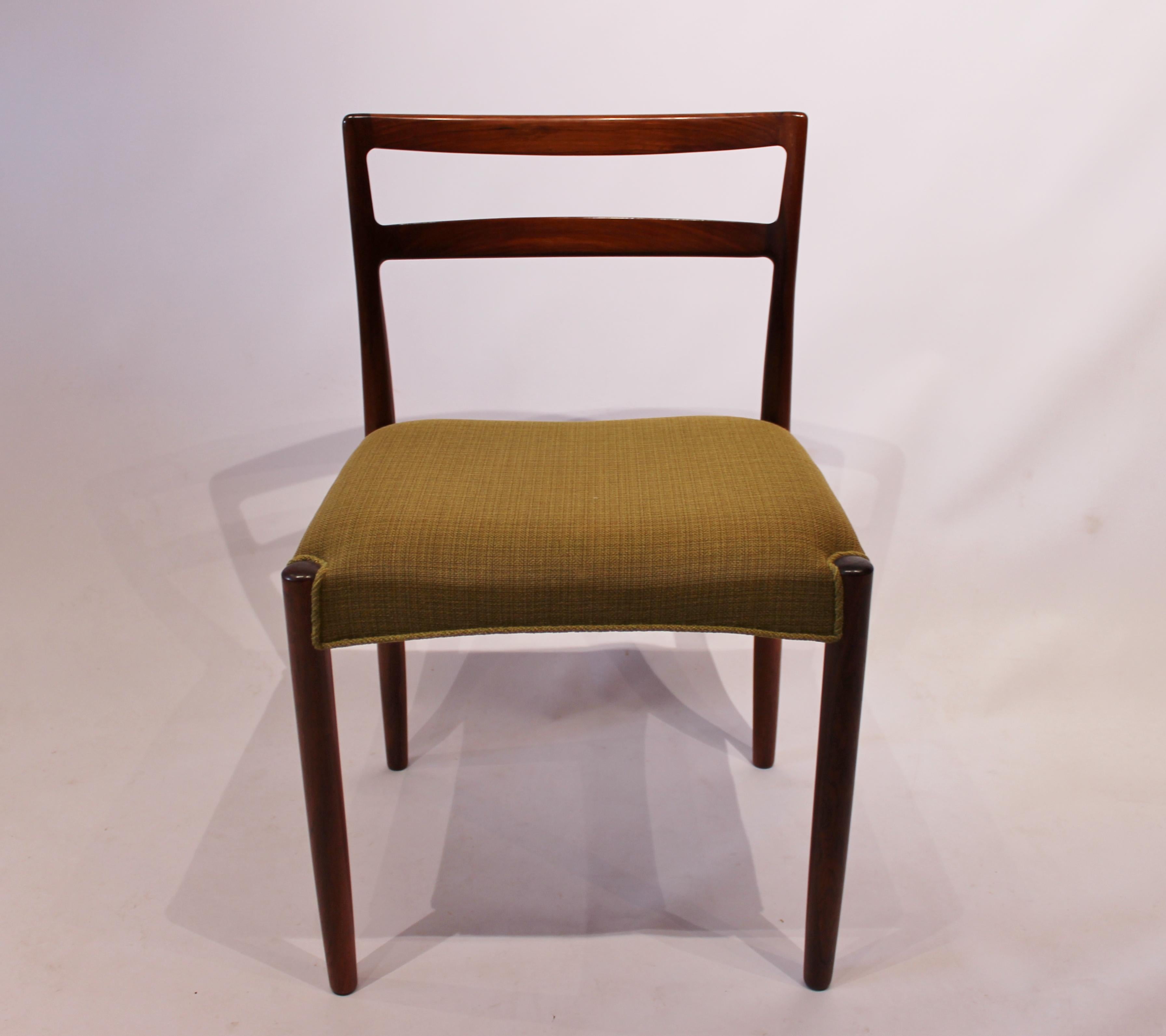 A set of dining room chairs of rosewood and upholstered with green fabric, of Danish design by Knud Færch from the 1960s. The chairs are in great vintage condition and numbered 6264.