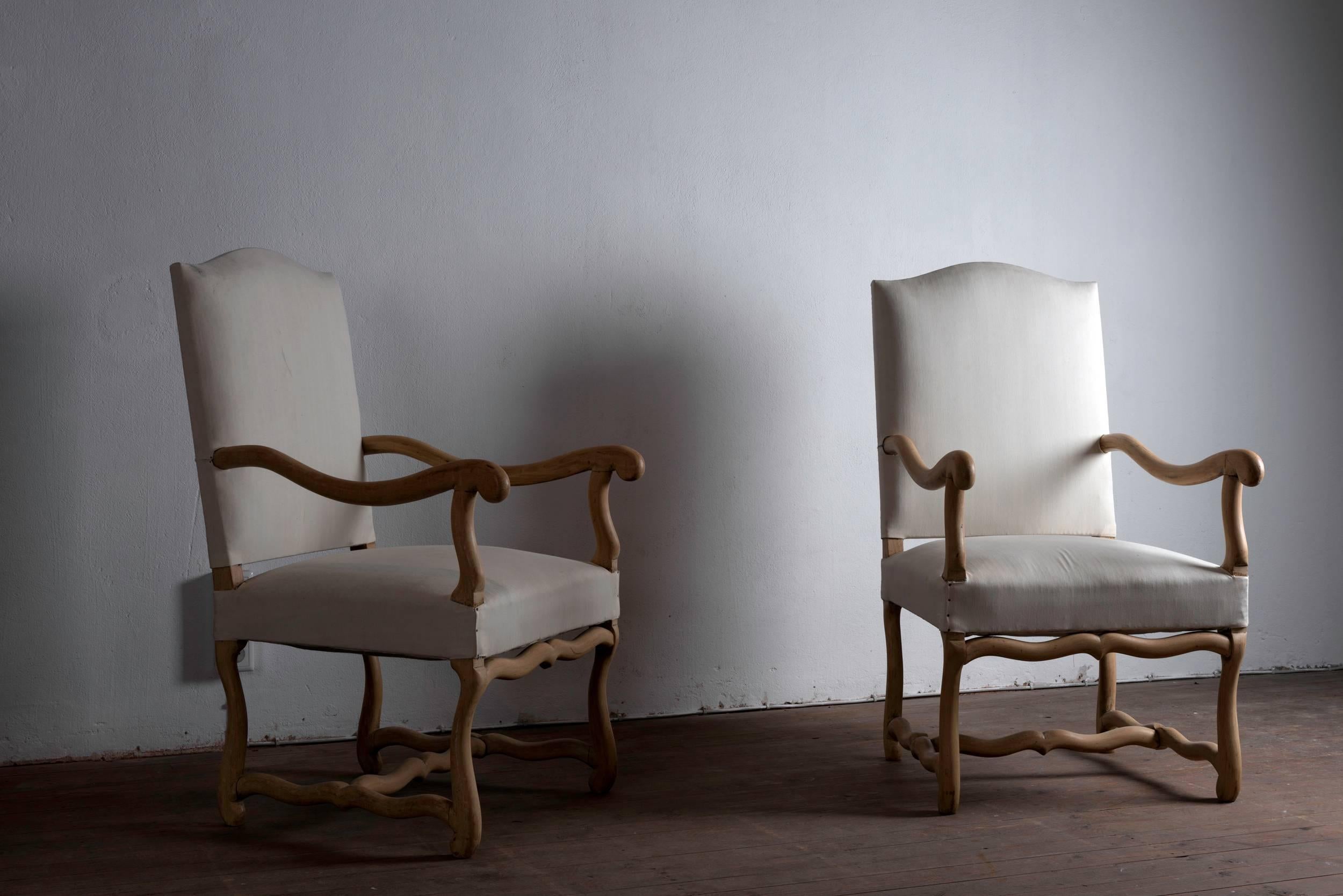 A set of eight antique French Os de Mouton dining chairs in bleached oak, comprising of six dinging chairs and a pair of armchairs, in bleached oak, covered in canvas.

      