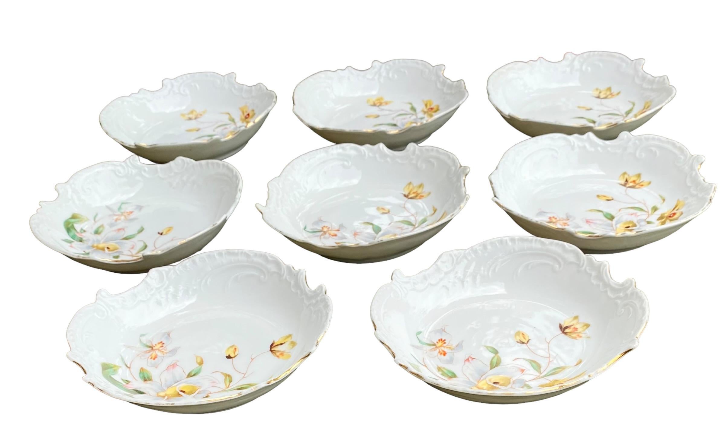 A set of eight delightful antique French porcelain bowls with embossed scrollwork and hand painted daffodils with vines and buds abound. Lovely to display in your vitrine or arranged in a wall assemblage in your dining room, living room, dressing