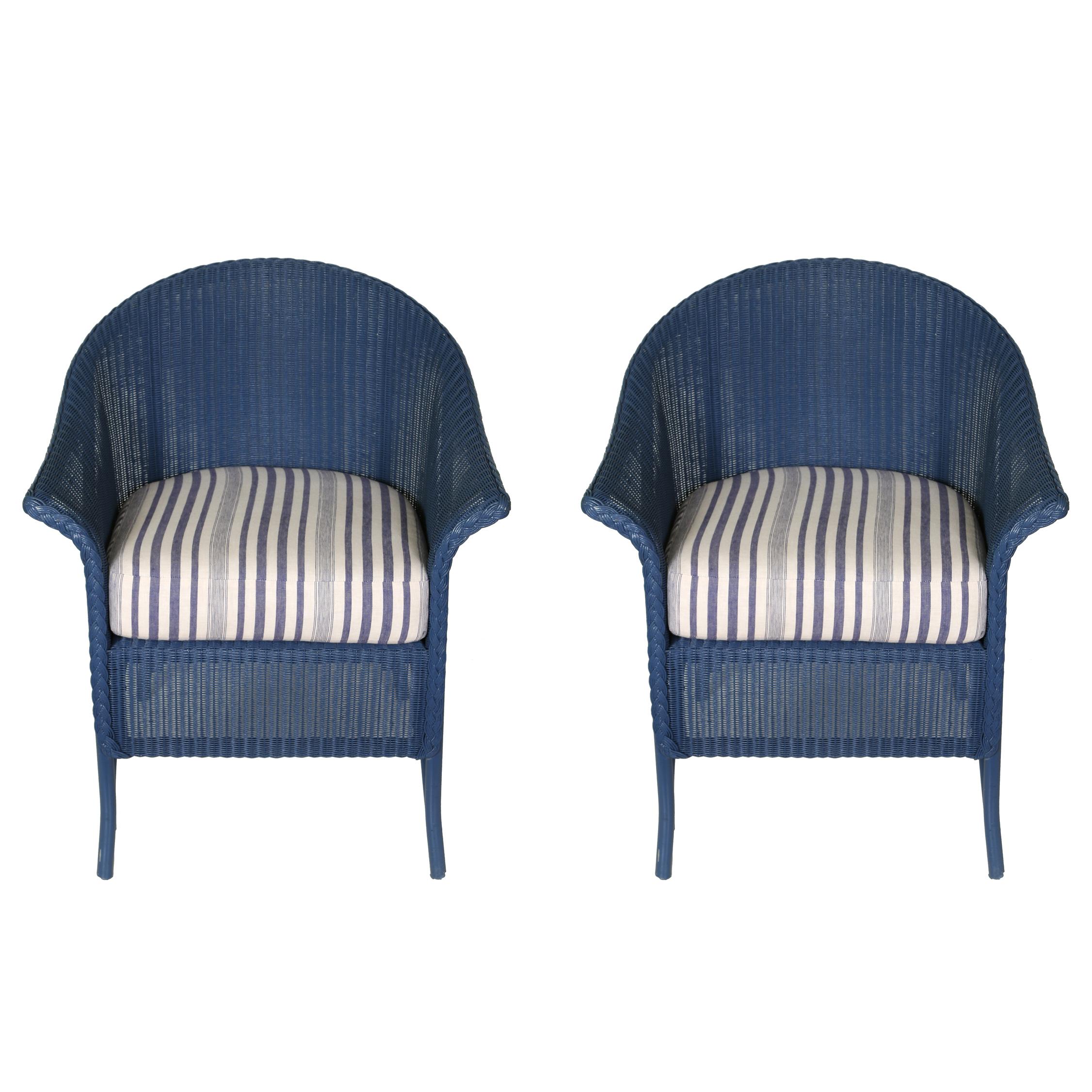 Un set di otto bellissime sedie da pranzo in vimini navy con cuscini in tessuto di cotone a righe bianche e blu.
