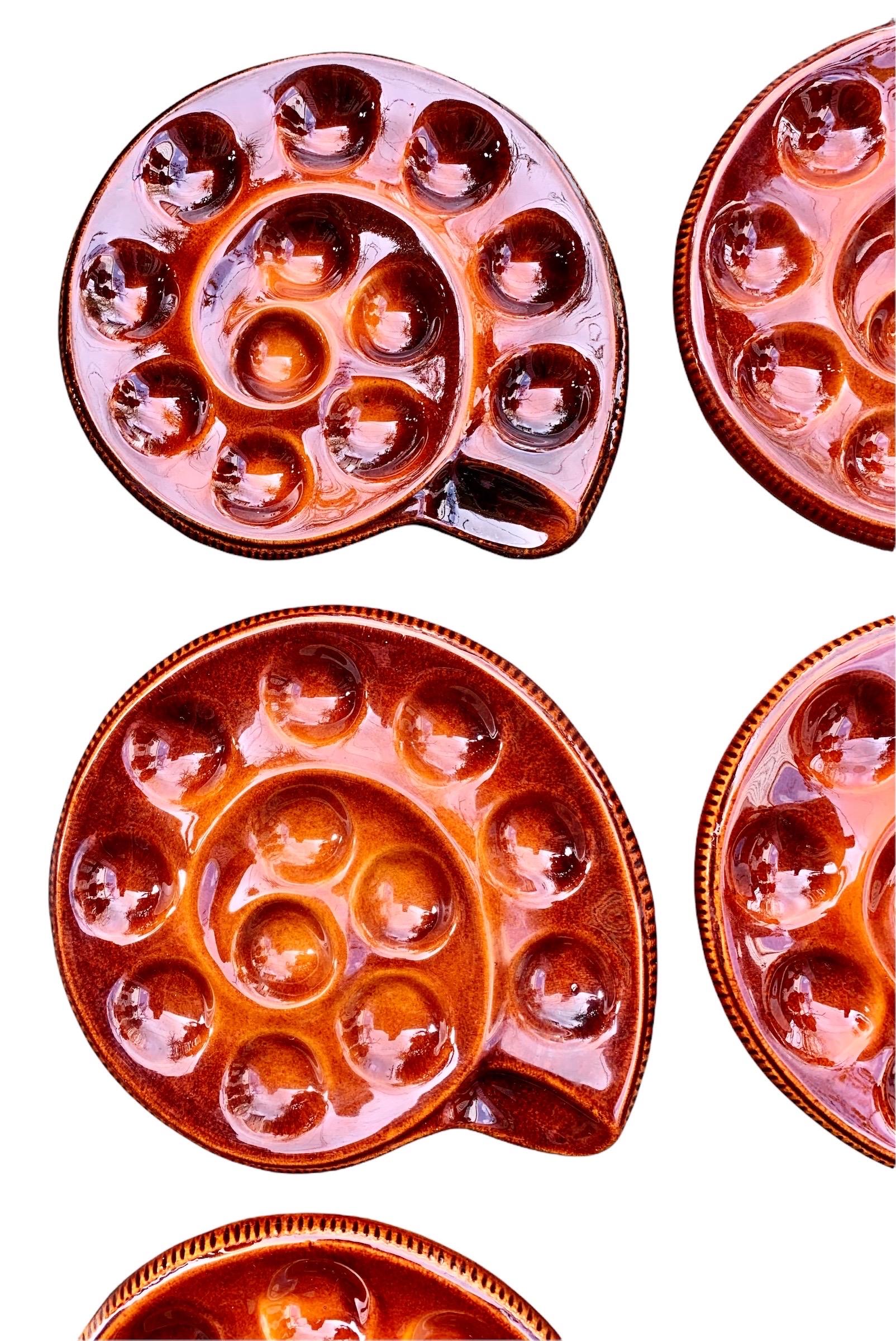 A stunning set of eight vintage French faience escargot plates by the French Faiencerie, St Clements, having twelve wells for your snails. Circa 1950's.

In the most charming shape of a snail and in a beautiful dark caramel color, these would set