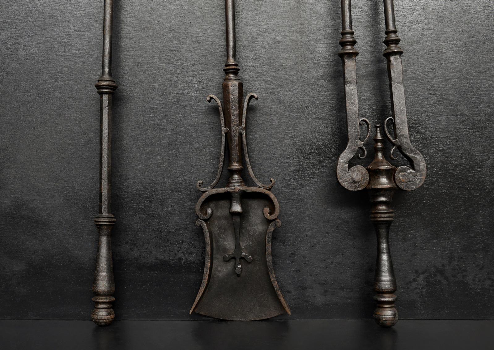 A very unusual set of fire tools. The poker with trident end, the shafts with scrolls and swells throughout and ball finial handles. English, circa 1800. (Could be polished if required)

Length:	890 mm      	35