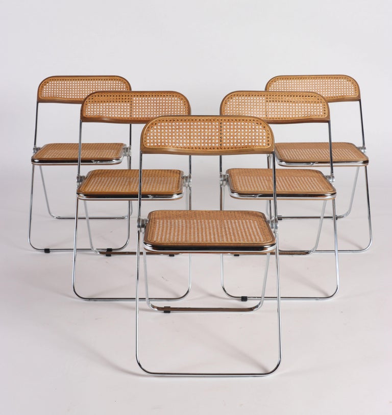 A set of five Italian chairs by Giancarlo Piretti for Castelli circa 1969.
 The chairs are made of a chrome frame with beige caning seating and back. 
 The textures fuse to create a beautiful form with function as well.