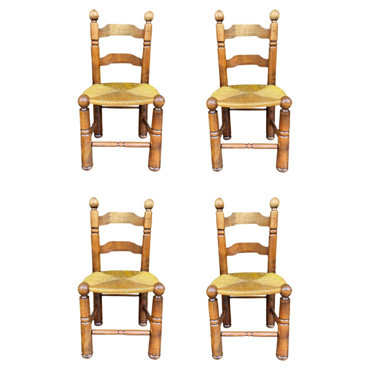 A set of four 1940s oak and woven rope seat dining chairs by Charles Dudouyt