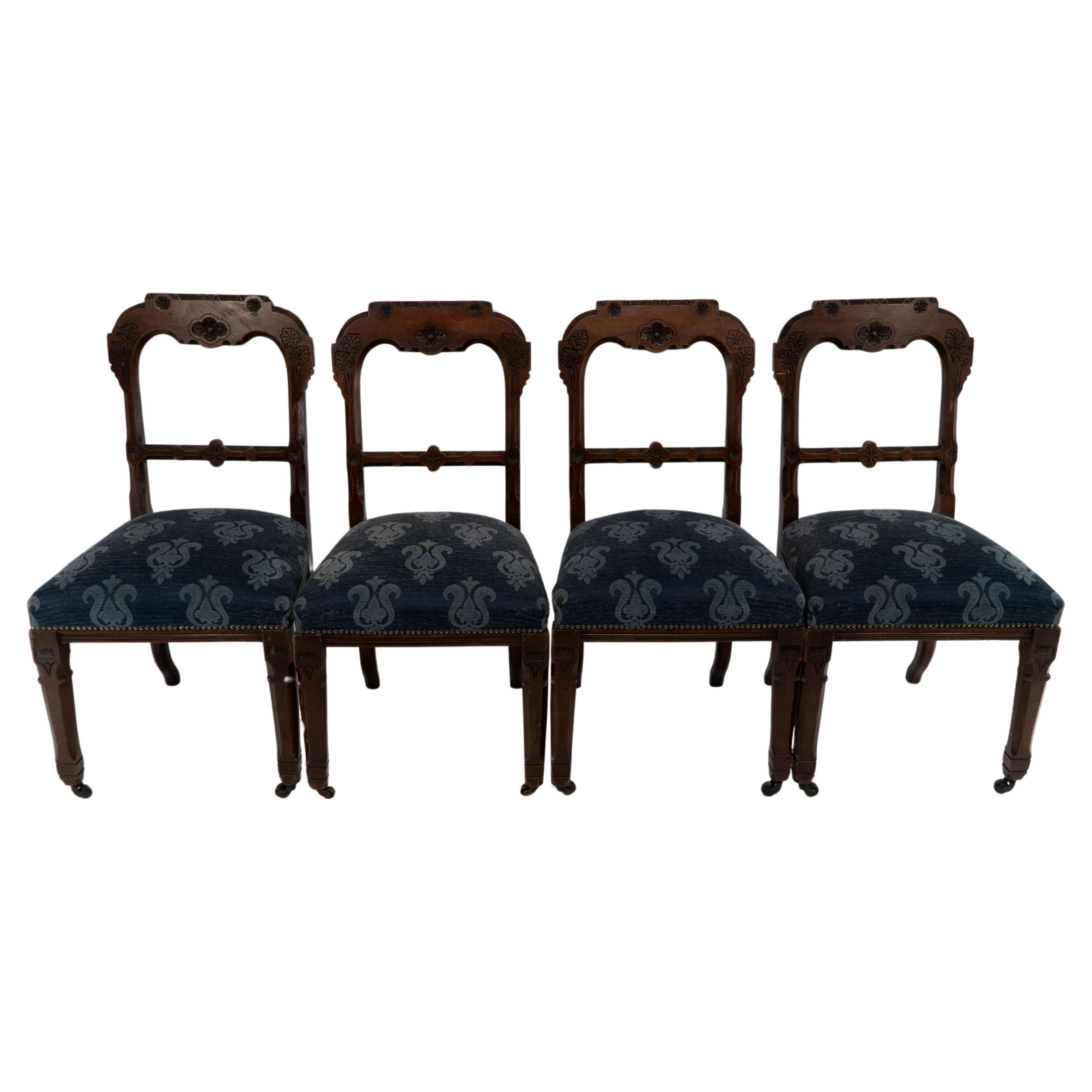 A set of four Aesthetic Movement oak dining chairs with carved decoration