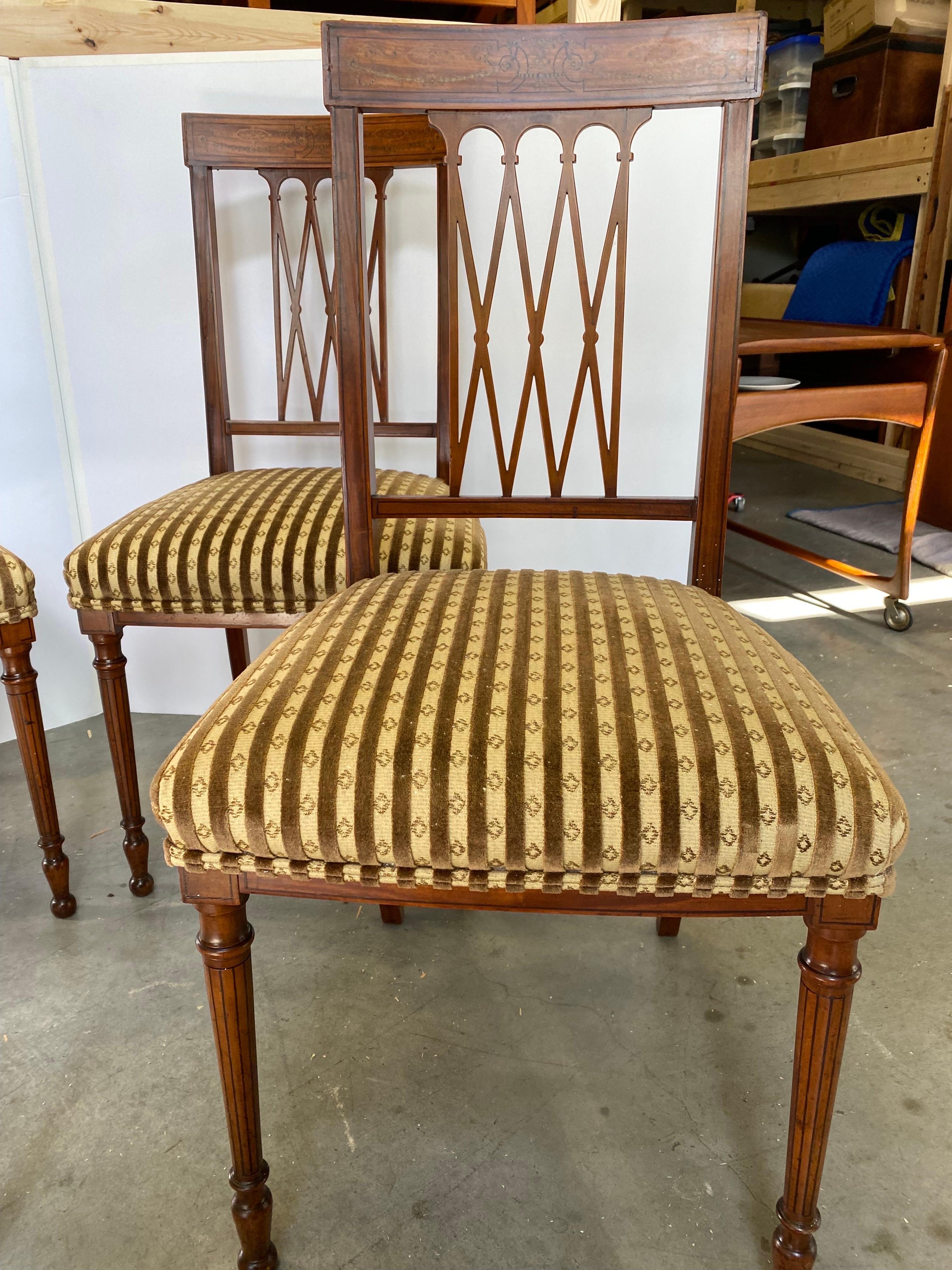Elegant set of four Edwardian side chairs in fruitwood with delicate inlay on the back rail and on the turned legs.  The lattice form backs with inlaid top rail with expensive velvet stripe fabric on the seats.  Teh finish has been professionally