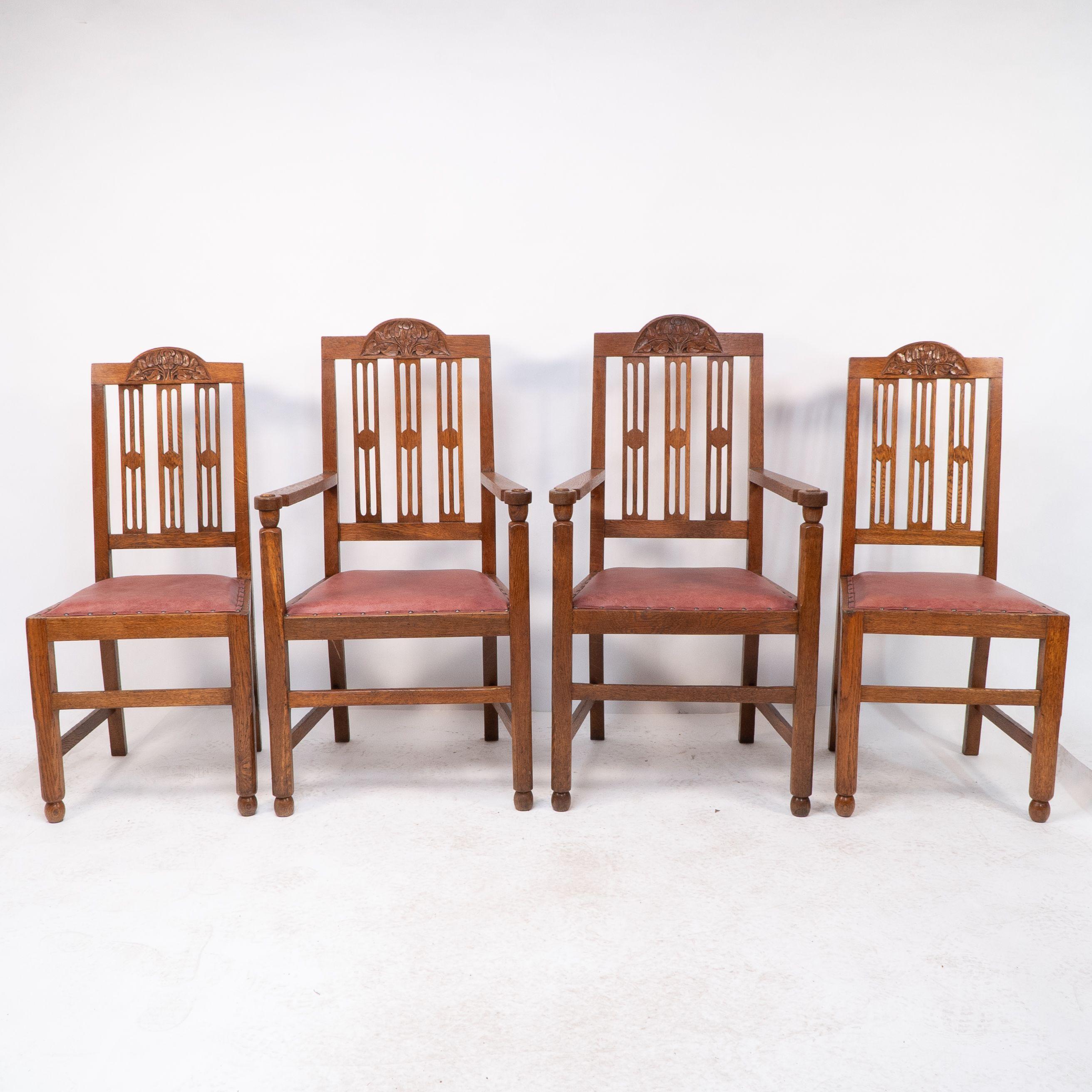A set of four Arts and Crafts dining chairs with nicely carved floral decoration to the head rails with slatted and circular details to the backs. The armchairs have ball details below the arms and to all of the front feet, the legs with subtle