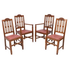 Un ensemble de quatre chaises de salle à manger Arts and Crafts avec une décoration florale joliment sculptée