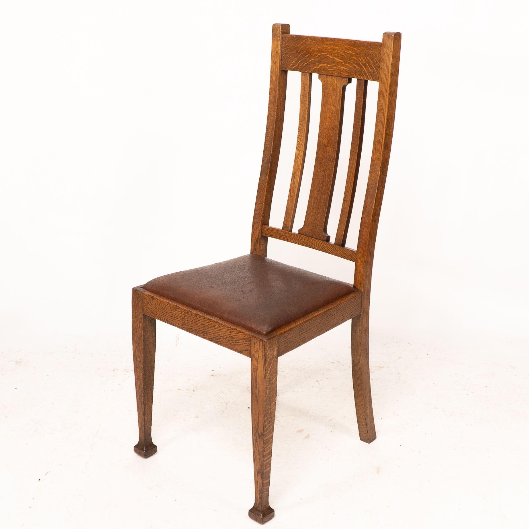 Un ensemble de quatre chaises de salle à manger en chêne de style Arts and Crafts avec des dossiers de forme confortable. Bon état - En vente à London, GB
