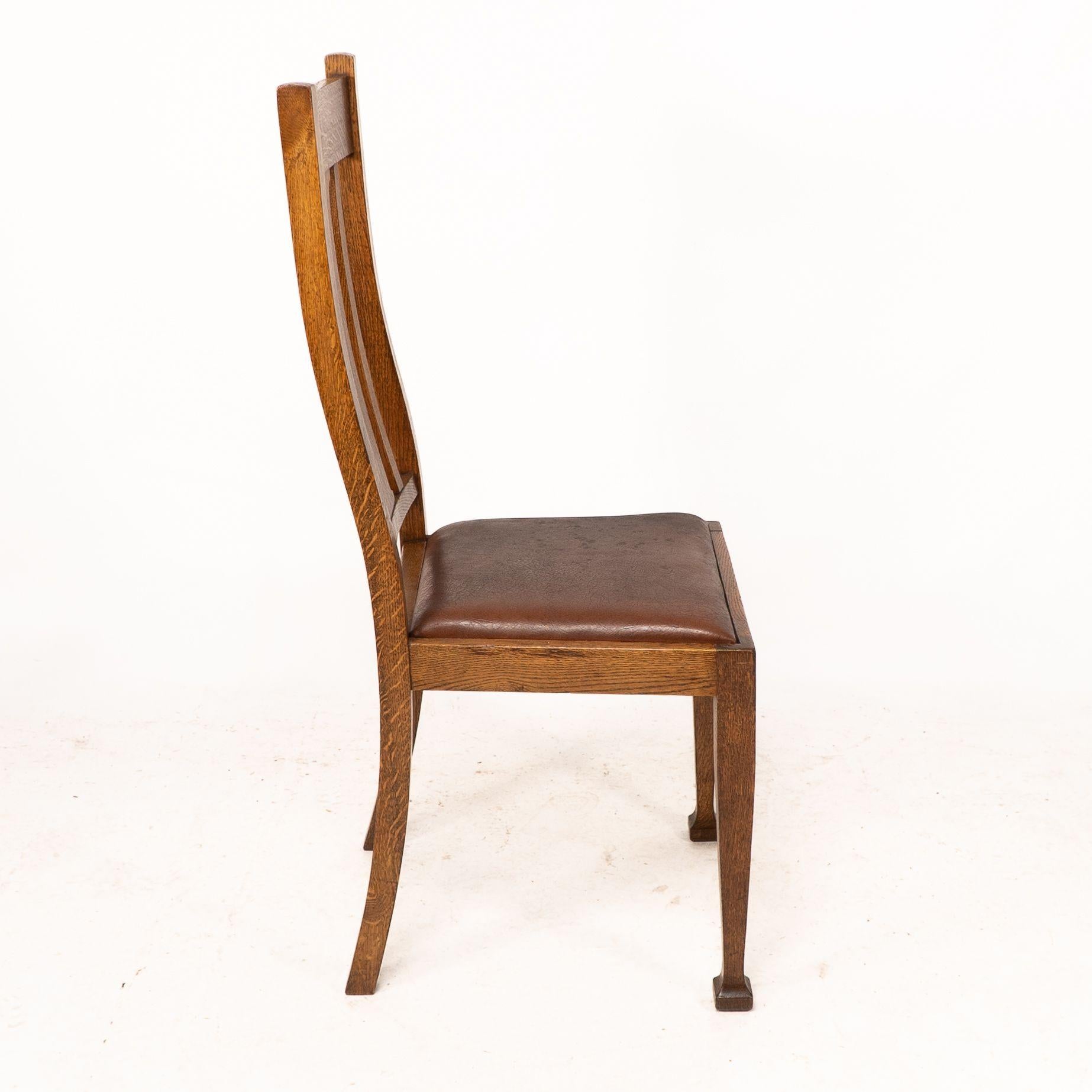 Début du 20ème siècle Un ensemble de quatre chaises de salle à manger en chêne de style Arts and Crafts avec des dossiers de forme confortable. en vente