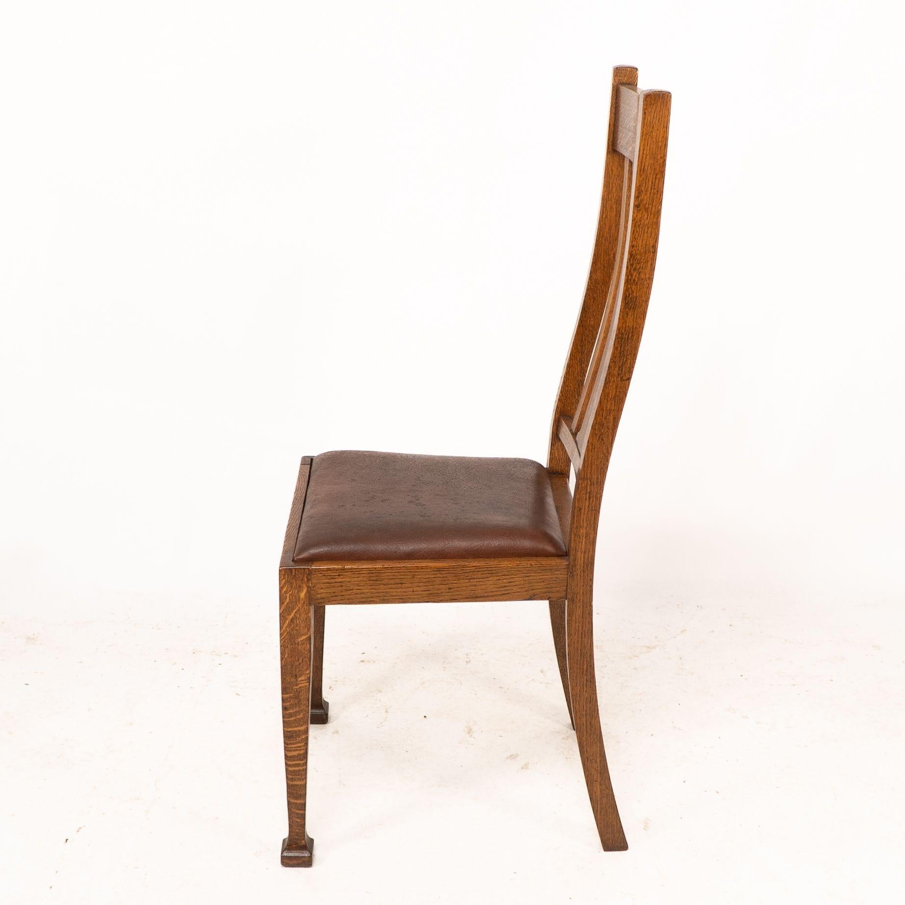Chêne Un ensemble de quatre chaises de salle à manger en chêne de style Arts and Crafts avec des dossiers de forme confortable. en vente