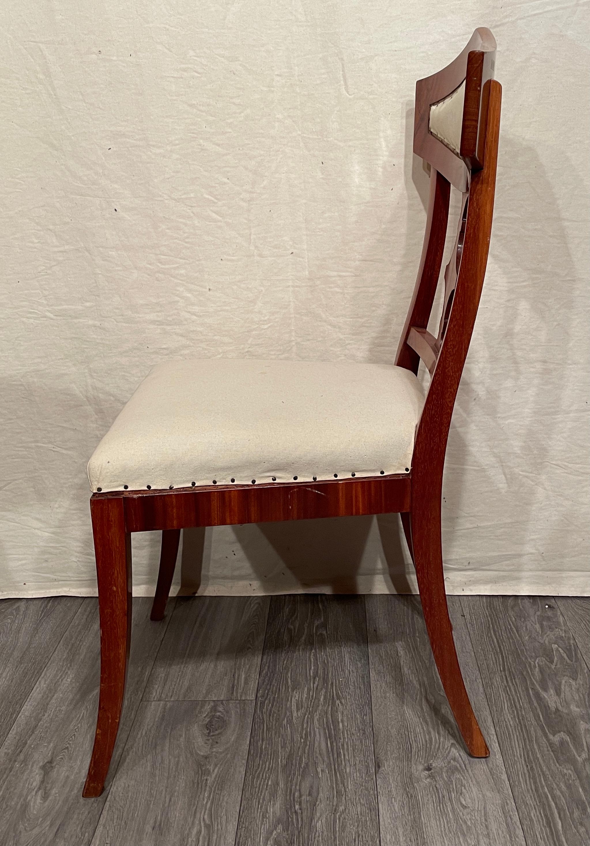 A set of four elegant Biedermeier chairs, mahogany veneer. The back has an elegant open work decor. 
The chairs are in very good condition. They have a new upholstery and you can choose a fabric for an additional fee. The chairs ship from Germany