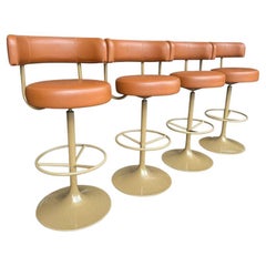 A set of four Börje Johanson “Jupiter” bar stools in cognac faux leather