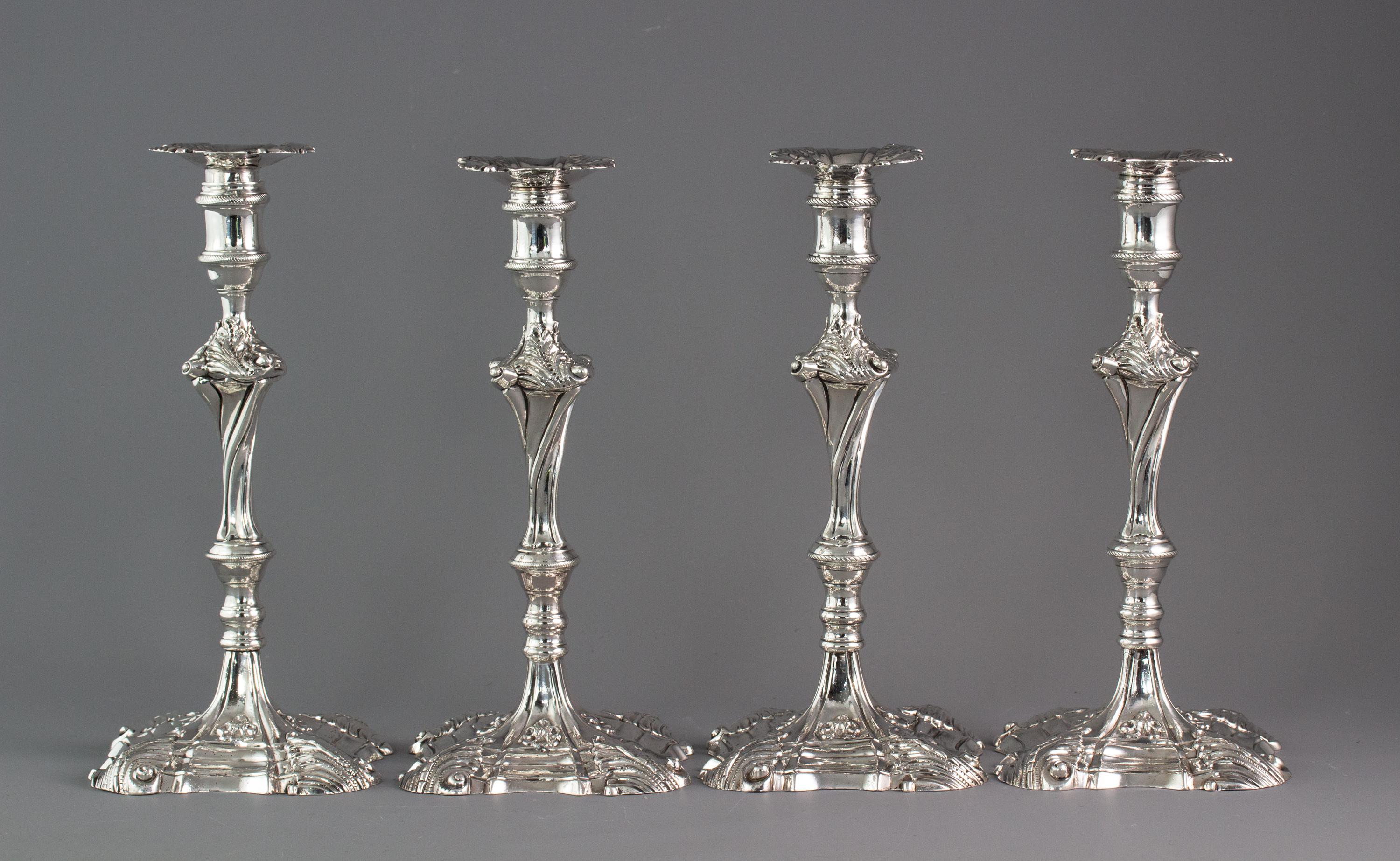 An exceptional set of four cast silver candlesticks, London, 1764-1765

An extremely fine set of four Georgian cast silver table candlesticks with leaf pattern decoration to the square shaped bases. A wrythen stem and leaf pattern and scroll form
