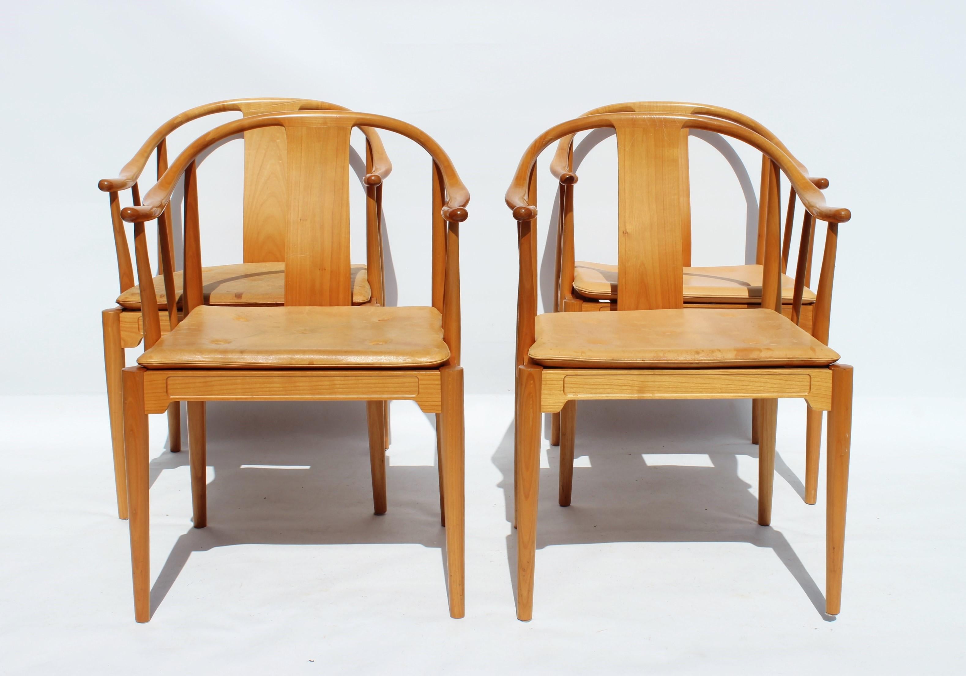 A set of four China chairs, model 4283, designed by Hans J. Wegner in 1944 and manufactured by Fritz Hansen in 1999. The chairs are of cherry and with cushion of patinated leather.