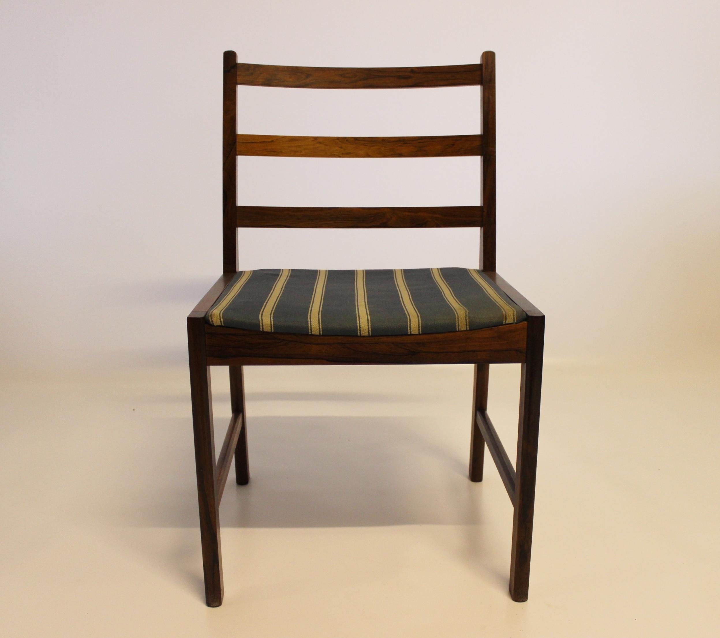 A set of four dining chairs in rosewood and seats upholstered with blue striped fabric, of Danish design from the 1960s. The chairs are in great vintage condition.

This product will be inspected thoroughly at our professional workshop by our