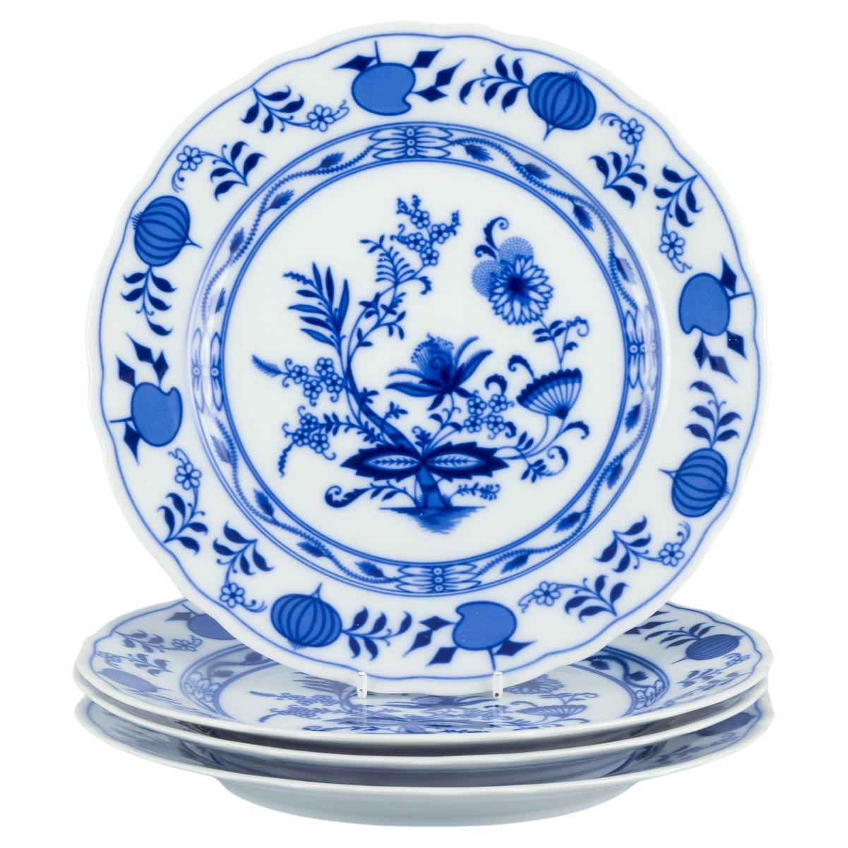 Ein Satz von vier Esstellern aus Porzellan mit Blaue-Zwiebel-Dekor.