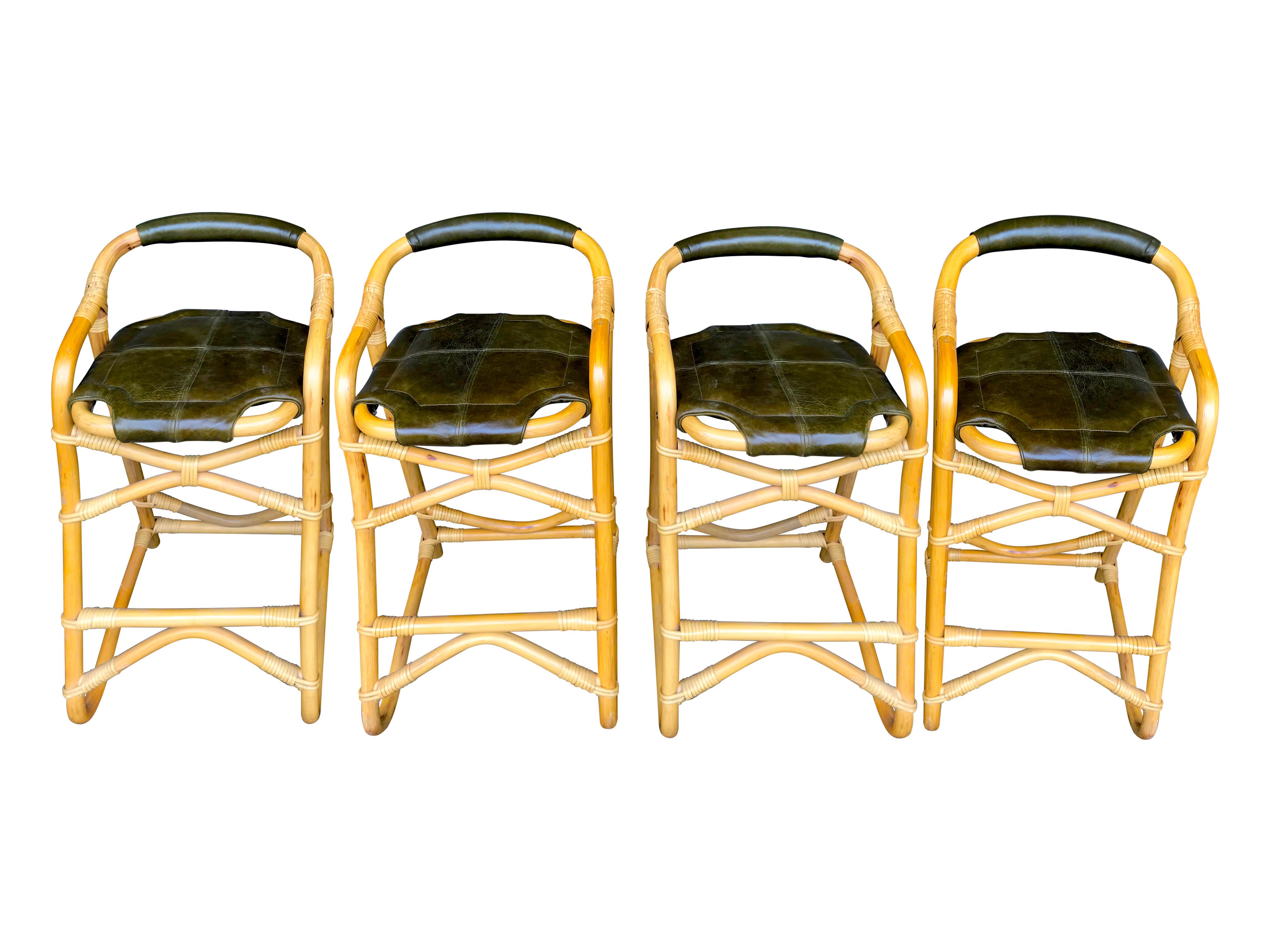 A set of four French Riviera bamboo bar stools with olive green leather seat pads and backs. The leather has a lovely patina and color and in very good condition. Good condition on all the bamboo and joints. All solid and structurally good.