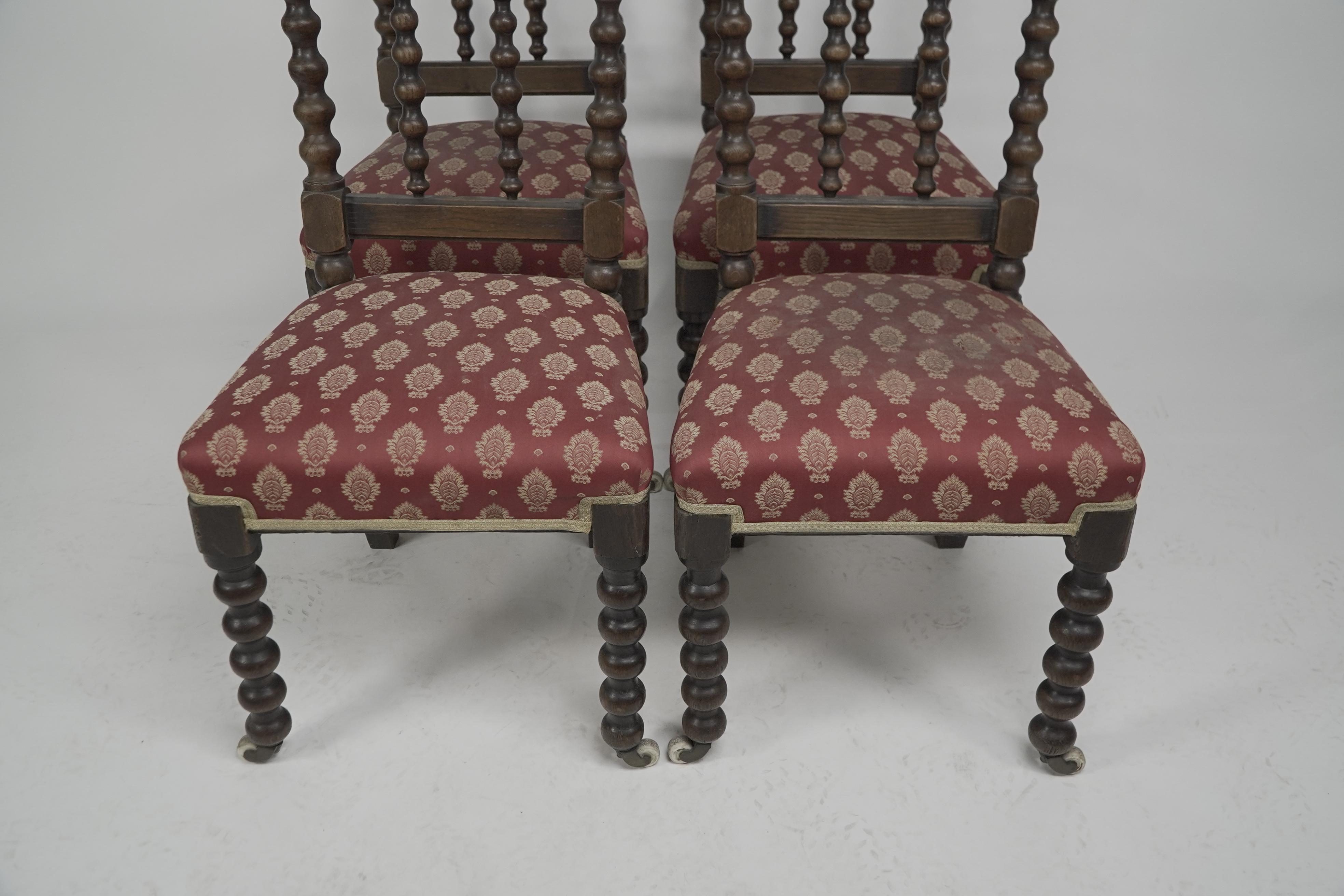 A good quality set of four Gothic Revival oak dining chairs with twin pierced quatrefoil details to the arched top and bobbin turned legs with original brass and white ceramic castors. Professionally reupholstered.
