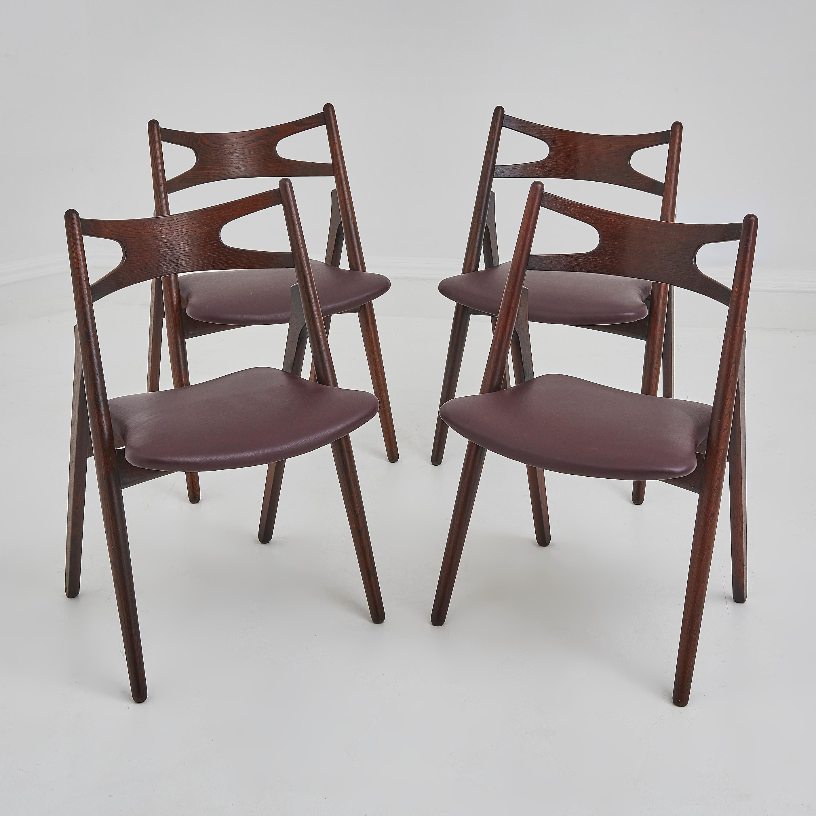 Questo set di quattro sedie da pranzo Hans Wegner Sawbuck CH29 esemplifica la maestria senza tempo e l'estetica raffinata del design danese di metà secolo. Caratterizzate da linee pulite, curve organiche e una meticolosa attenzione ai dettagli,