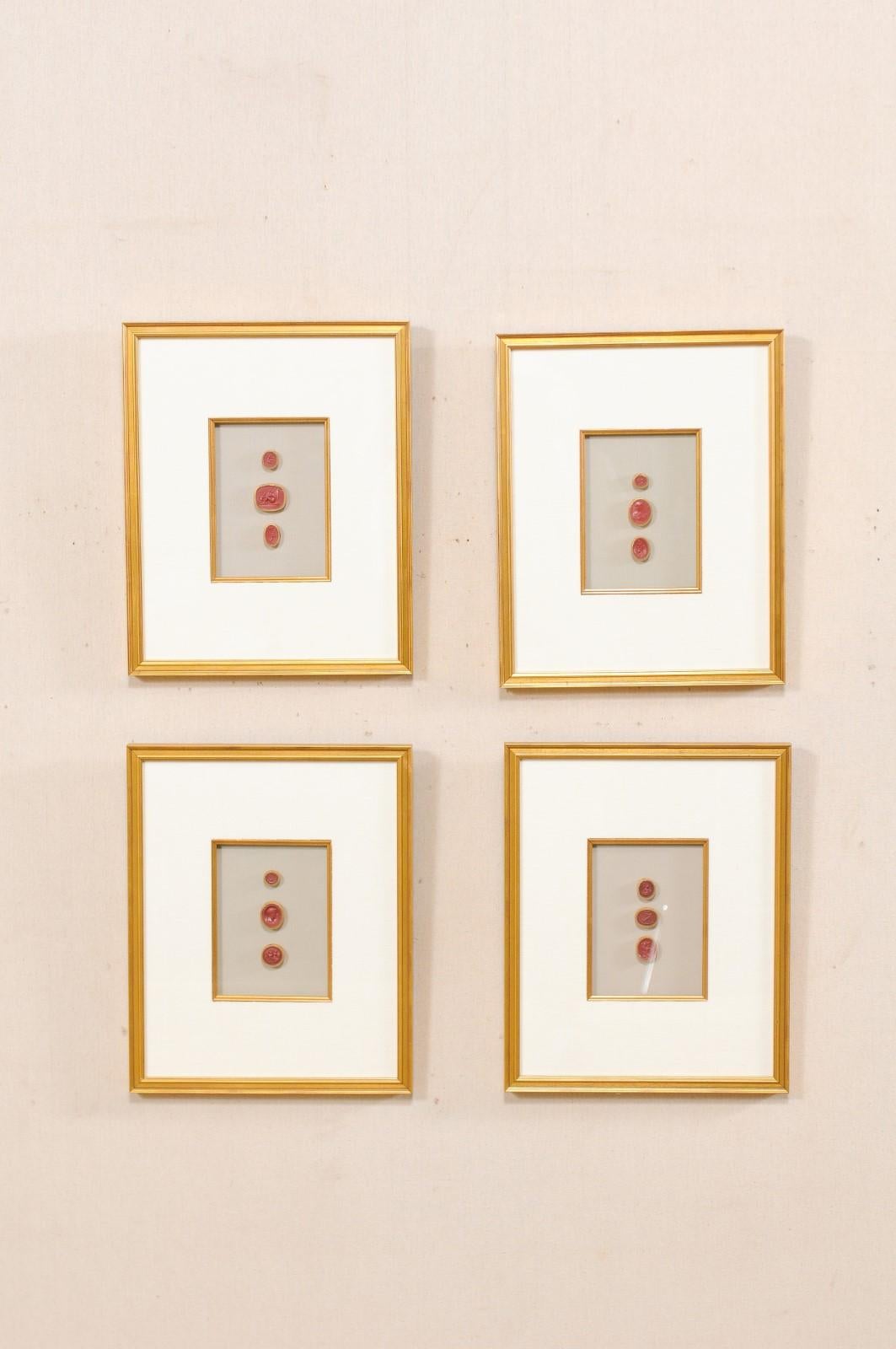 A set of four neoclassical Italian red intaglios from the mid-20th century, displayed nicely within gold custom frames. This set of red colored vintage Italian intaglios have been set within custom wood framed shadow boxes with gold accents. These