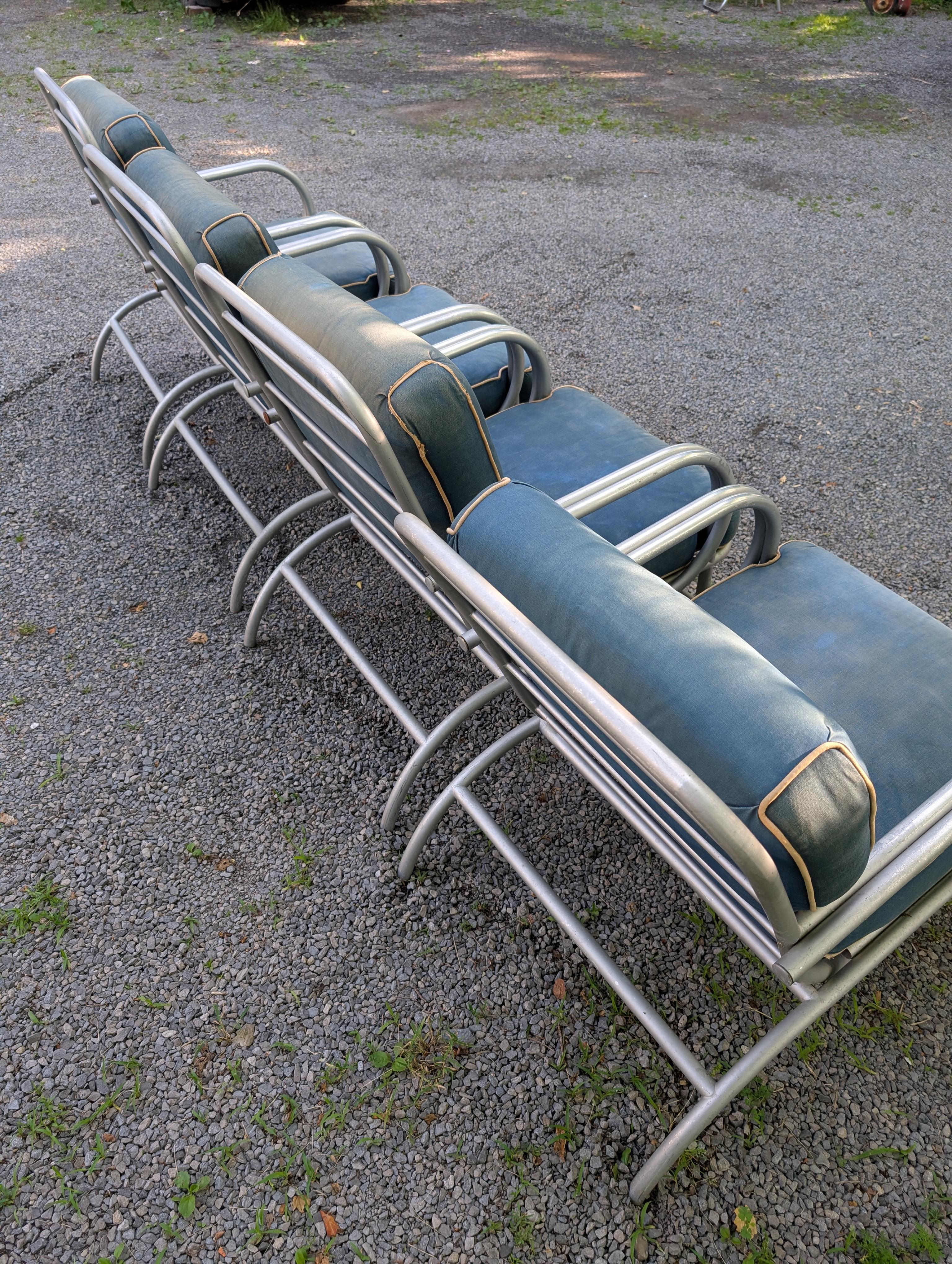 A great set of curved arm chairs from the 1950's. For the patio or garden, made of aluminum with original blue upholstery. Modernist design and comfortable to use.