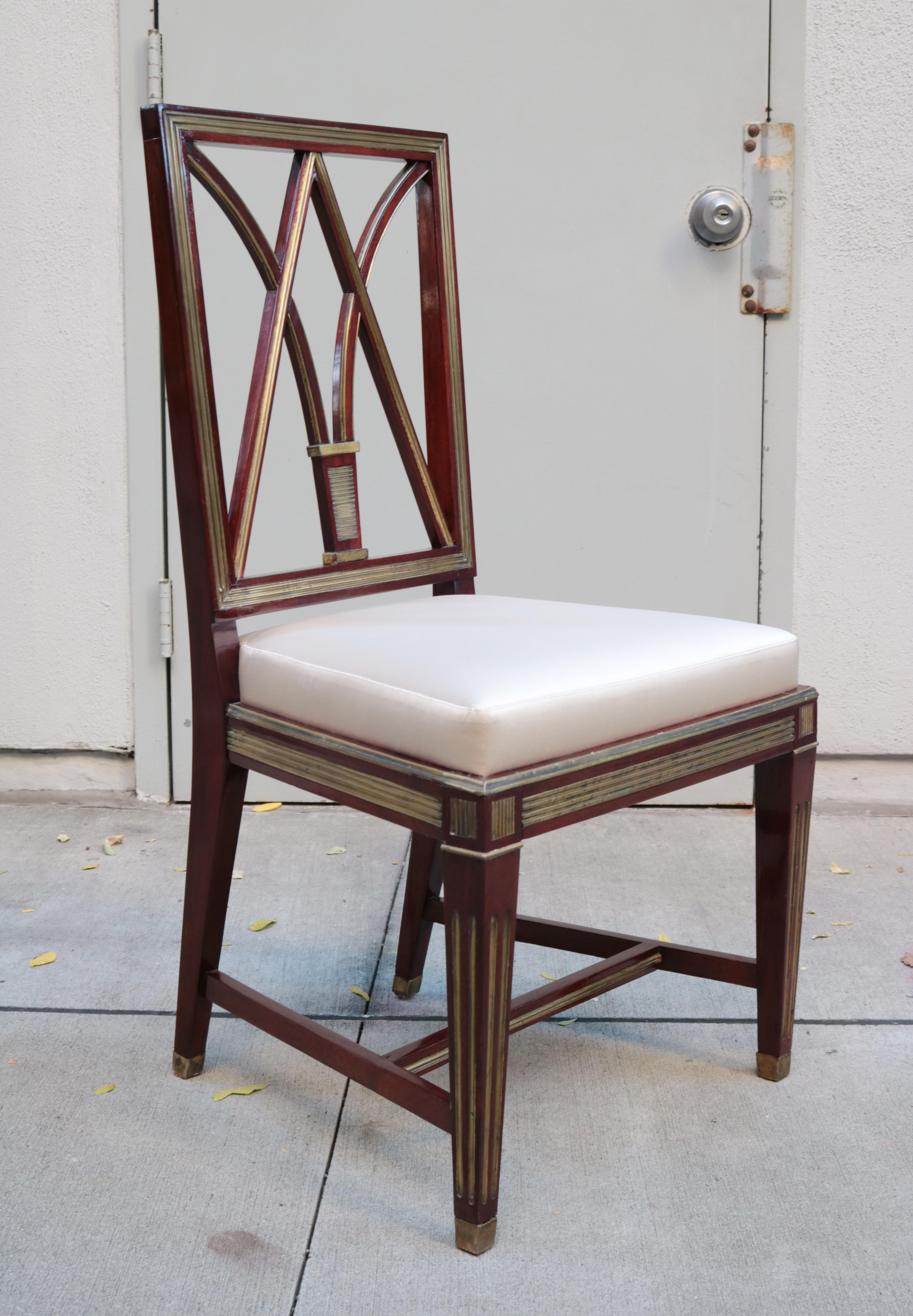 Un ensemble de quatre chaises d'appoint néoclassiques.
Acajou avec incrustations, détails et sabots en laiton patiné.