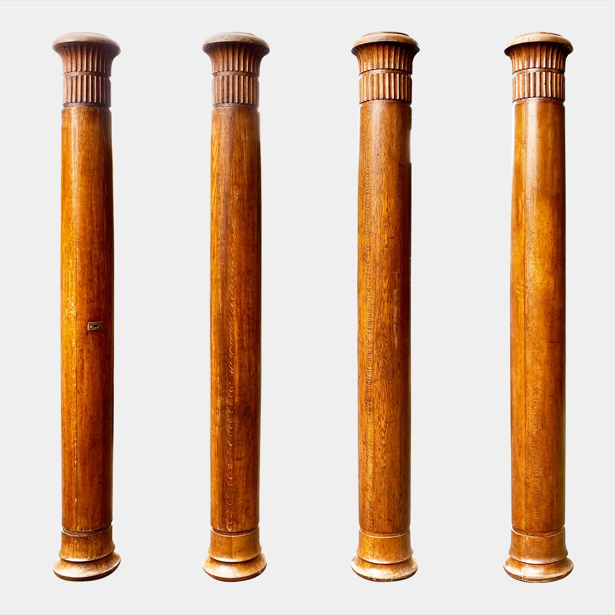 A set of four oak columns, with finger flute capitals and carved socle bases. Two being slightly taller than the others. Fantastic patina retaining some of the brass from the Theatre they were removed from, one with the Isle letter P still attached.