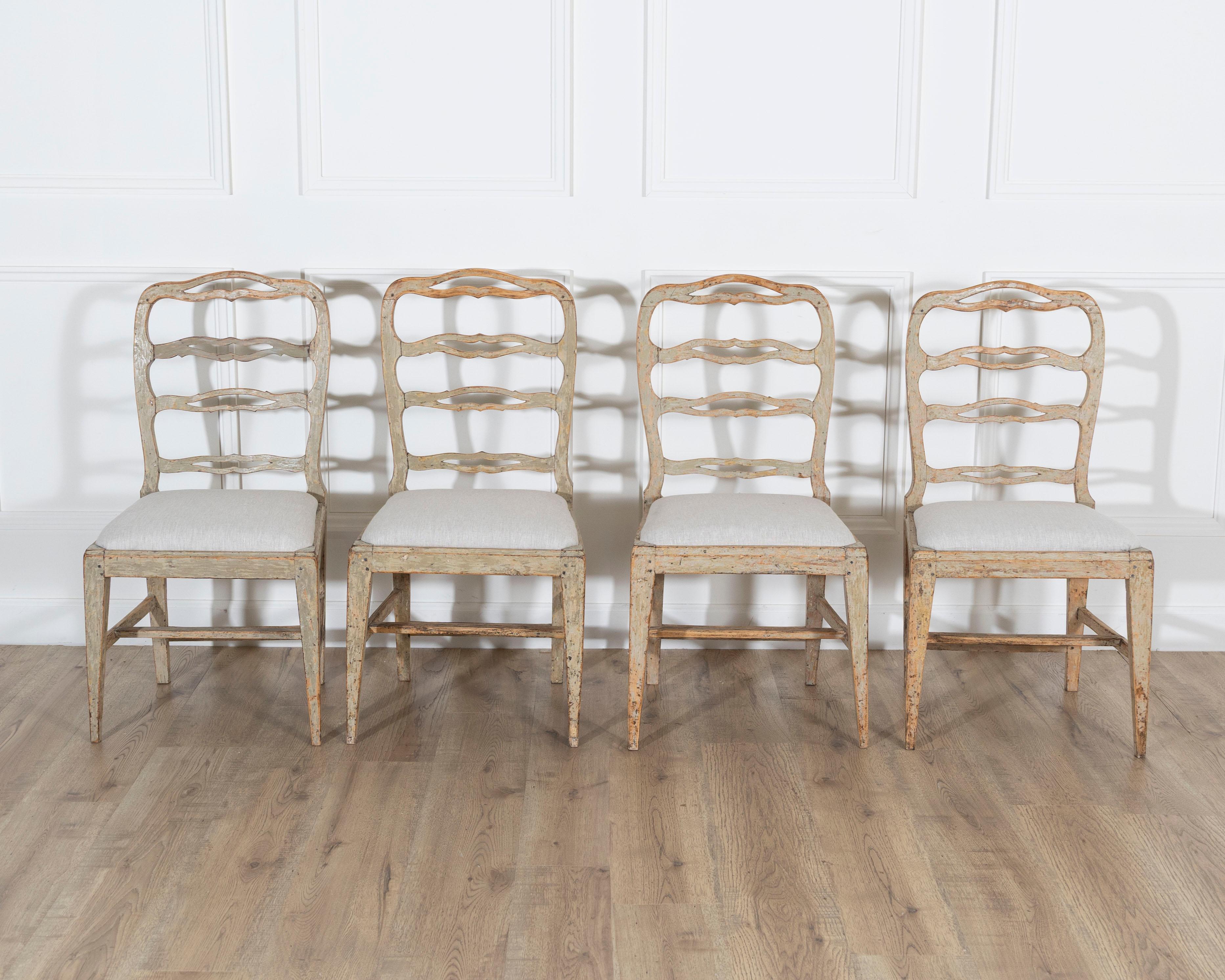 A refined set of four period Gustavian chairs from Sweden, late 18th to early 19th century, each scraped to reveal traces of their original paint. These chairs embody the restrained elegance and natural harmony that define the Gustavian aesthetic —