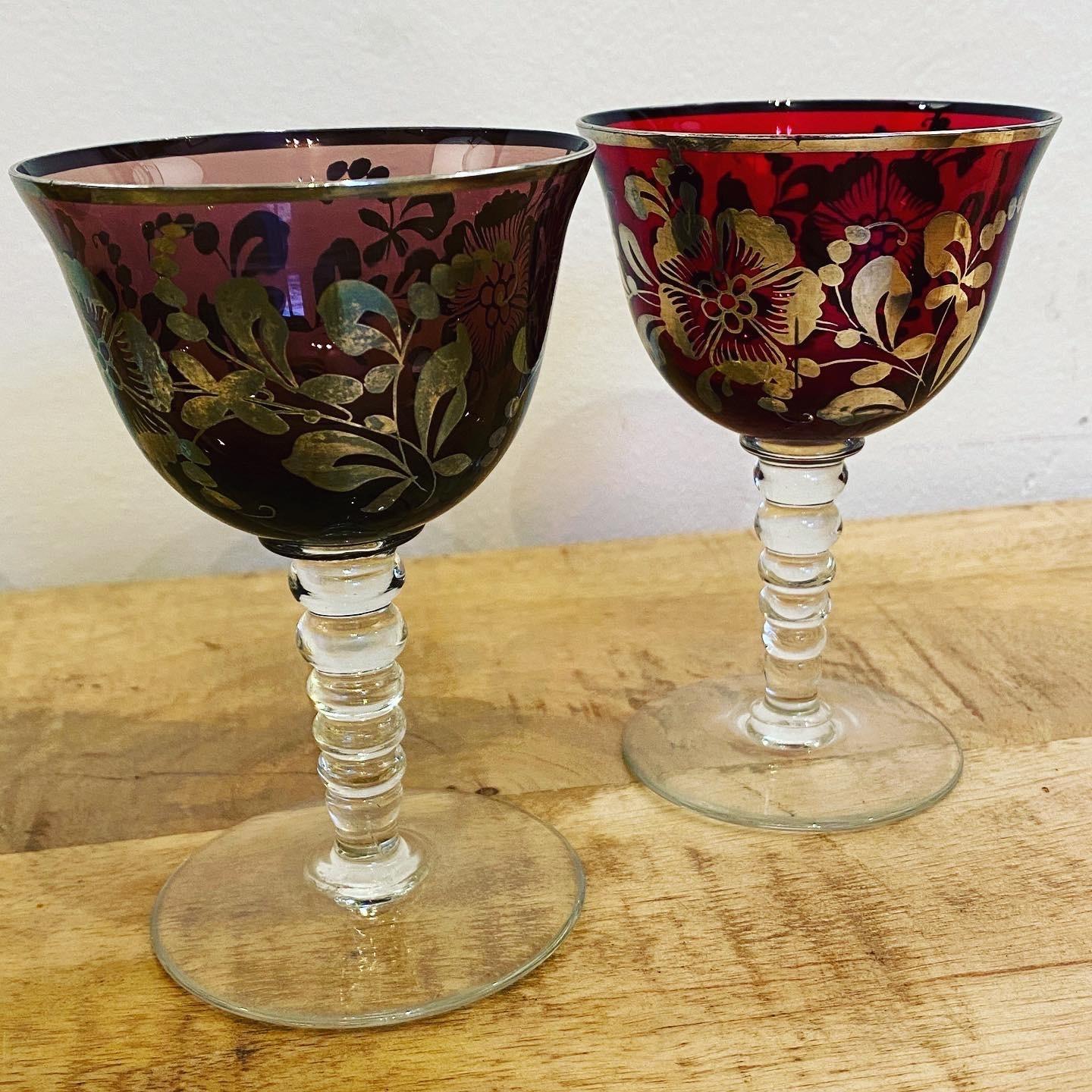 A lovely set of four Bohemian glasses. The colored glass with applied silver leaf and floral decoration. Standing on a beaded stem.