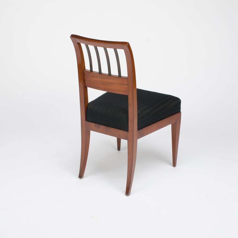 A set of four restored Biedermeier side chairs in mahogany, circa 1840. The frames resting on tapered square legs. Upholstered with black silk fabric.