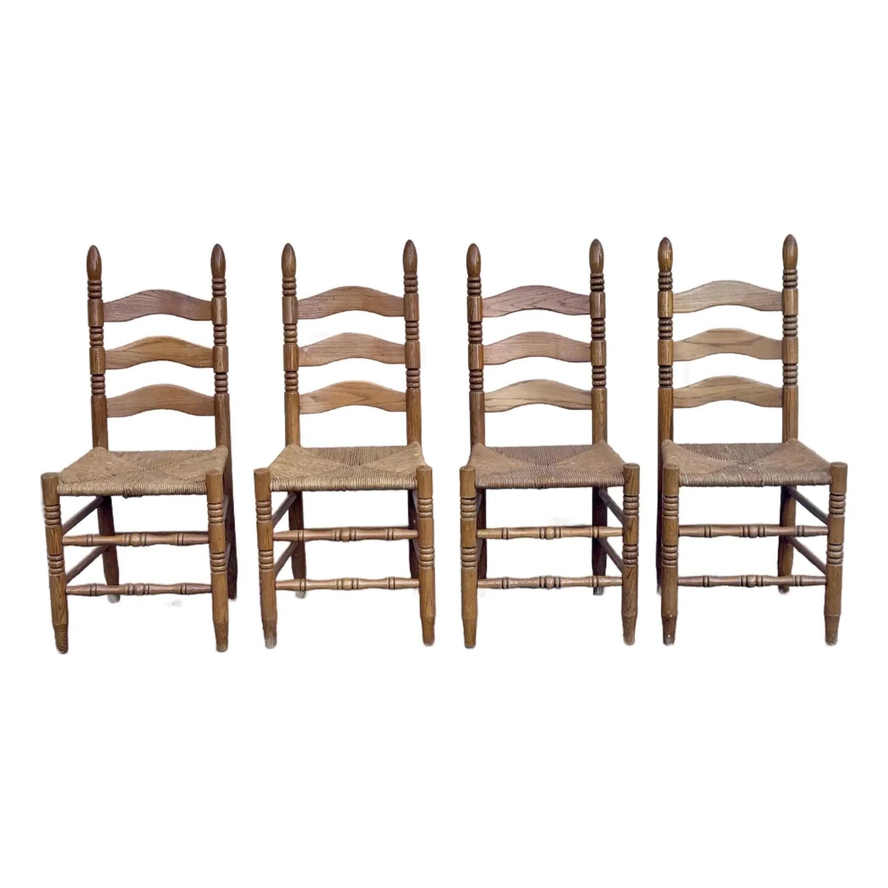 A set of 4 charming dining chairs made of rustic oak with rush seats and ladder-style back.



