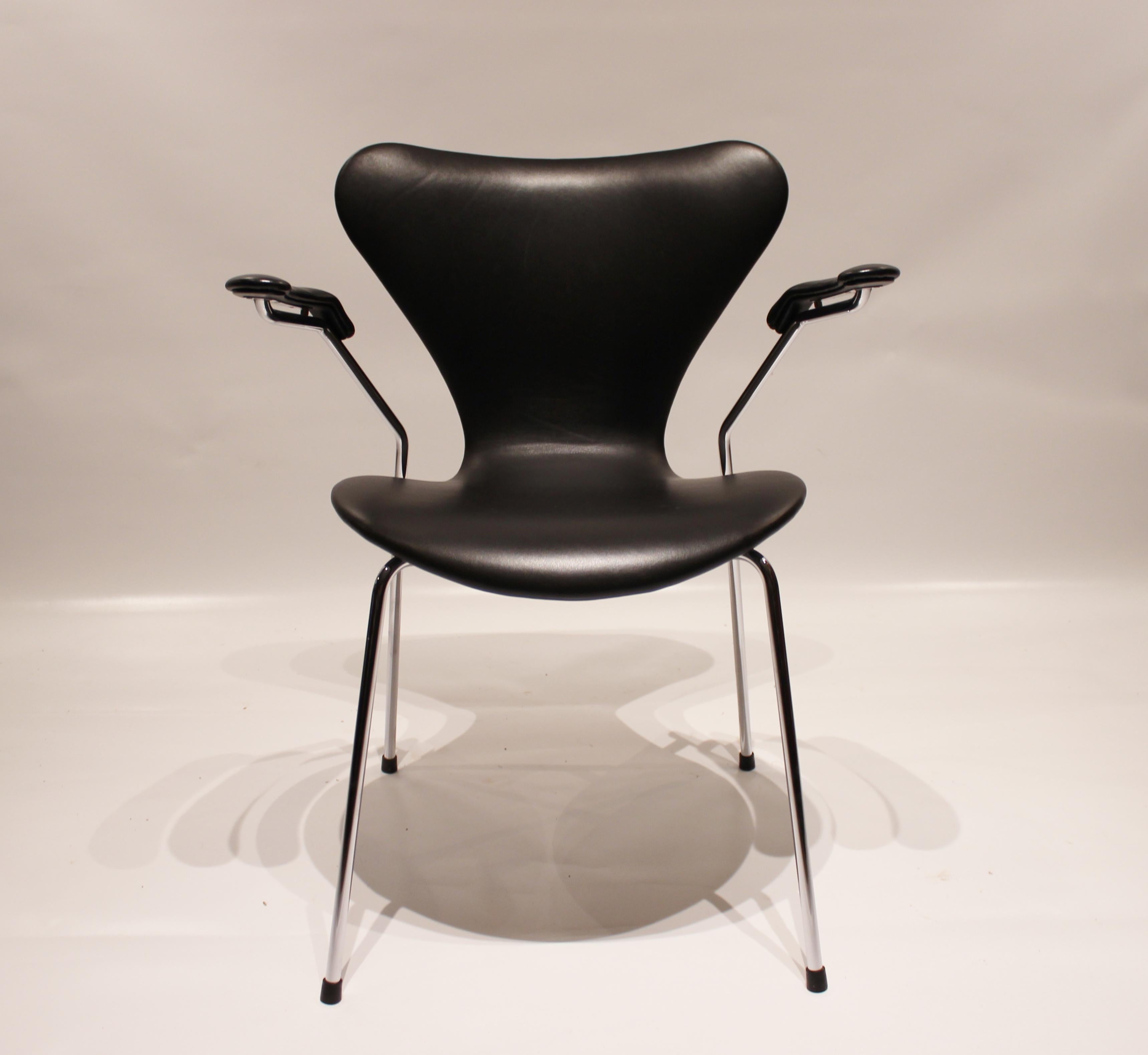 A set of four seven chairs, model 3207, with armrests in black Classic leather designed by Arne Jacobsen in 1955 and manufactured by Fritz Hansen in 2006. The chairs are in great vintage condition.
