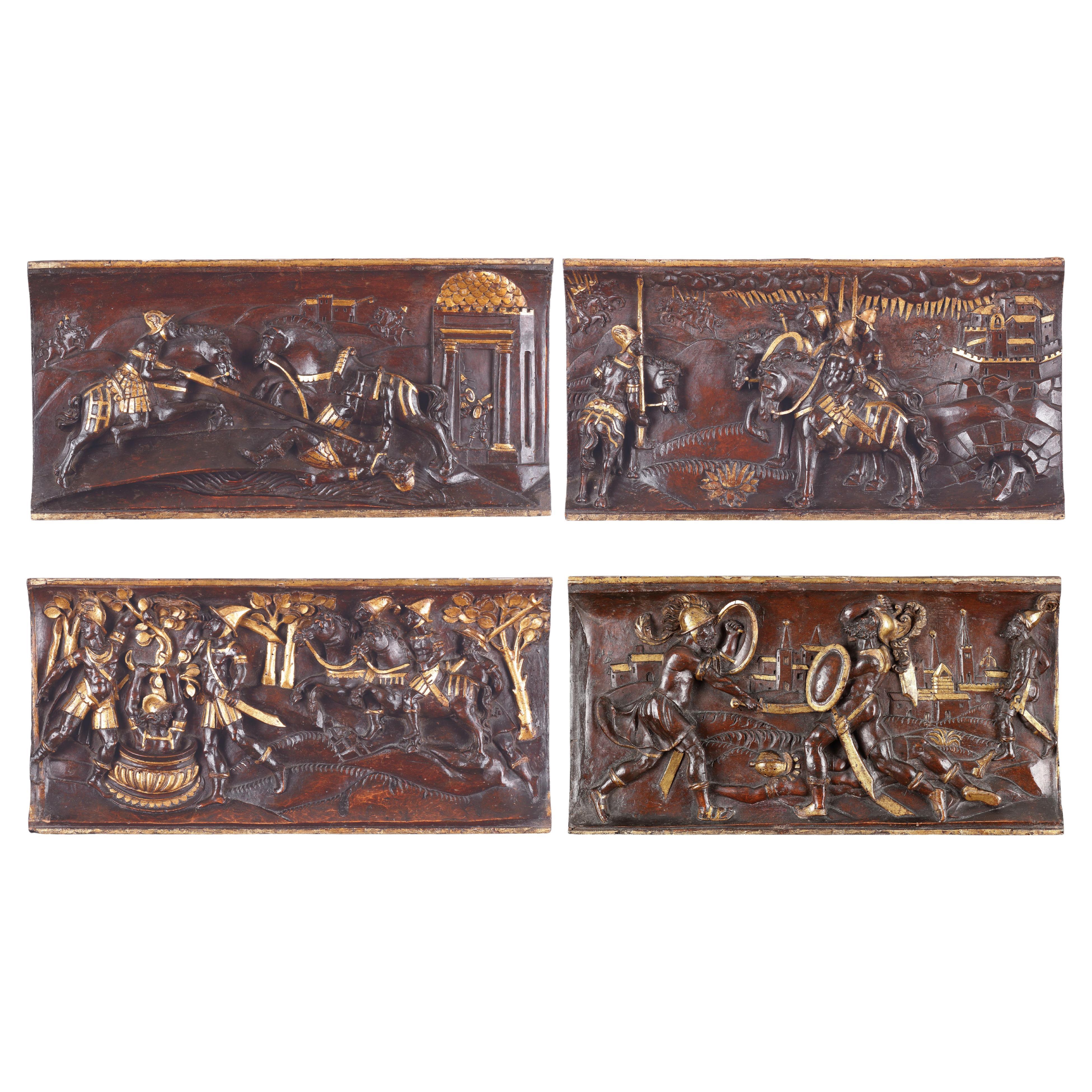 Ensemble de quatre reliefs équestres toscans en bois sculpté et parcellaire doré en vente