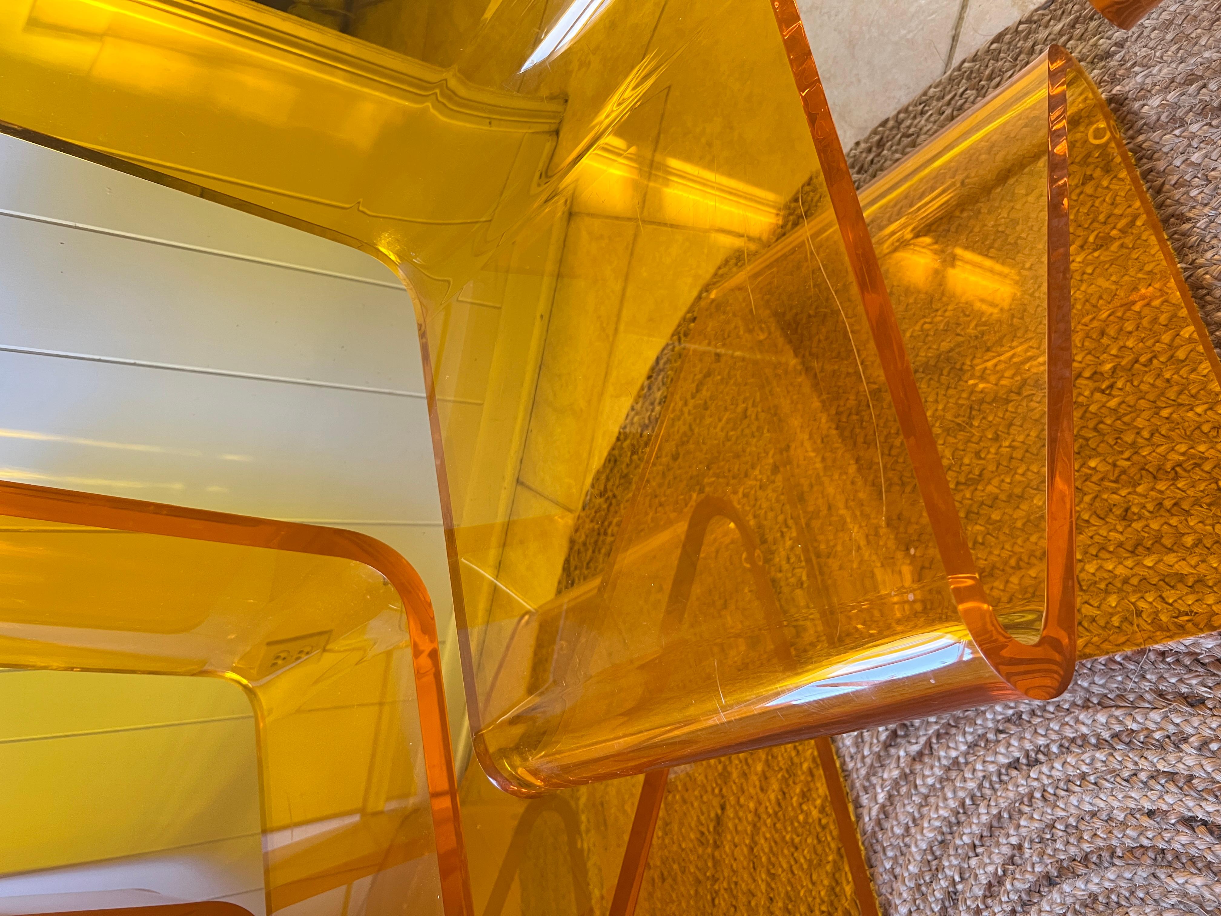 Conjunto de cuatro sillas Z de Haziza en color naranja. La Silla Z es reconocida por su forma arquitectónica, su color atrevido y su resistente Lucite. En lucita de la más alta calidad y 2,5 cm de grosor, la silla Z consigue encajar a la perfección