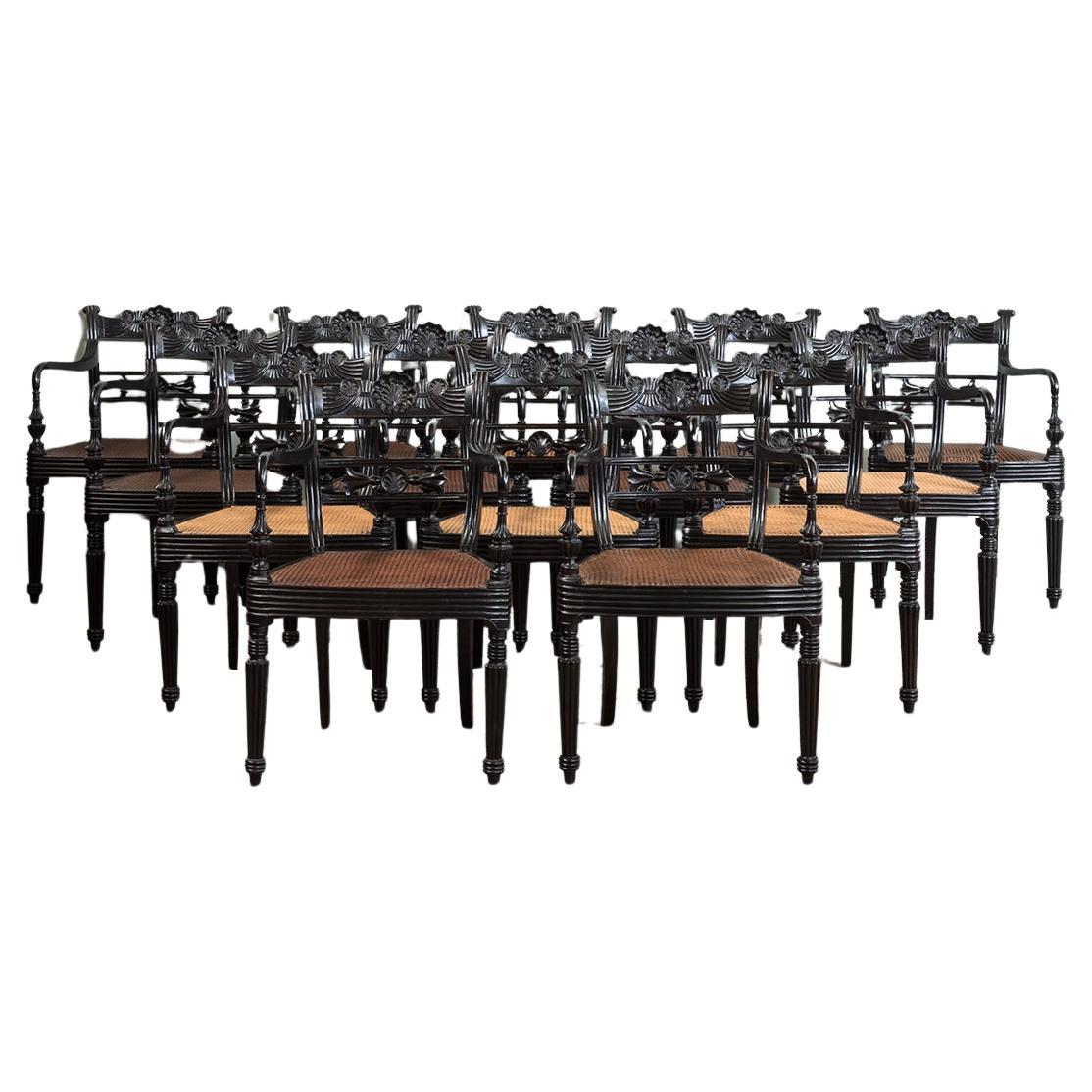 A Set of Fourteen Early 19th Century Anglo Indian Carved Ebony Armchairs For Sale