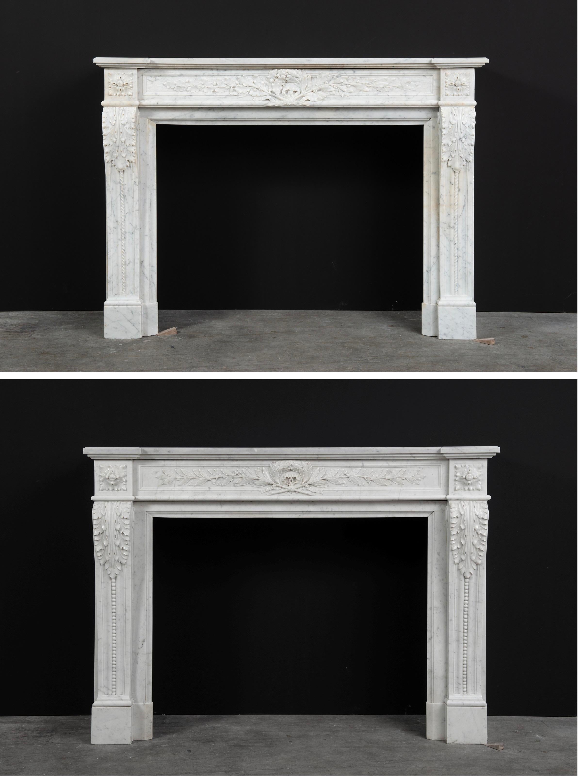 A set of French Antique Louis XVI fireplaces in white Carrara marble.

Both antique fireplaces have strong and well profiled stepped topshelf above a finely carved paneled friezes with beautiful laurel leaves flanked by floral paterae. The