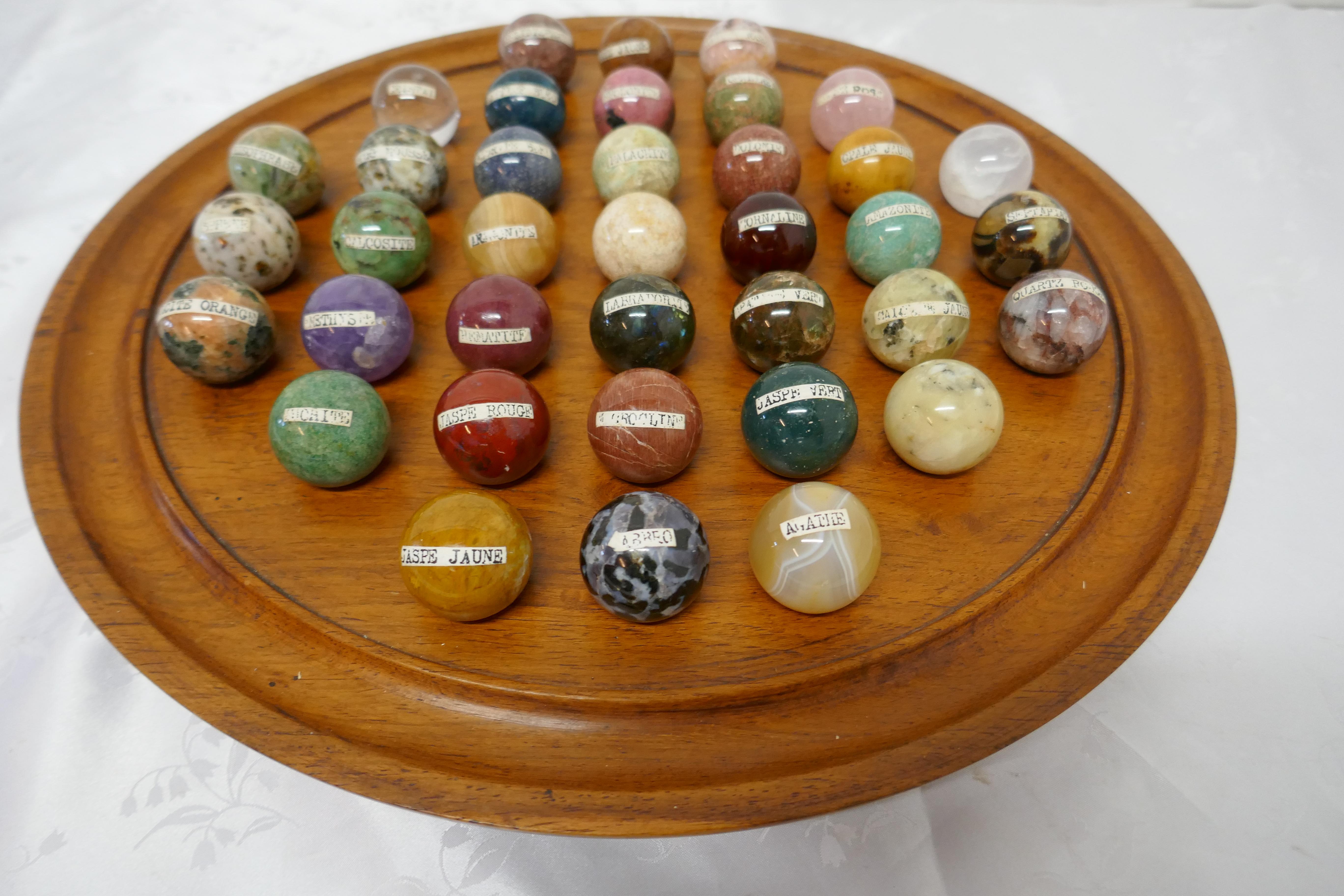 A set of French marble orbs on a turned solitaire board

This is a great collection, there are 37, 3cm marbles, made in mostly marble but some other minerals, all but 3 are labeled with their French names, they are set on a turned a walnut