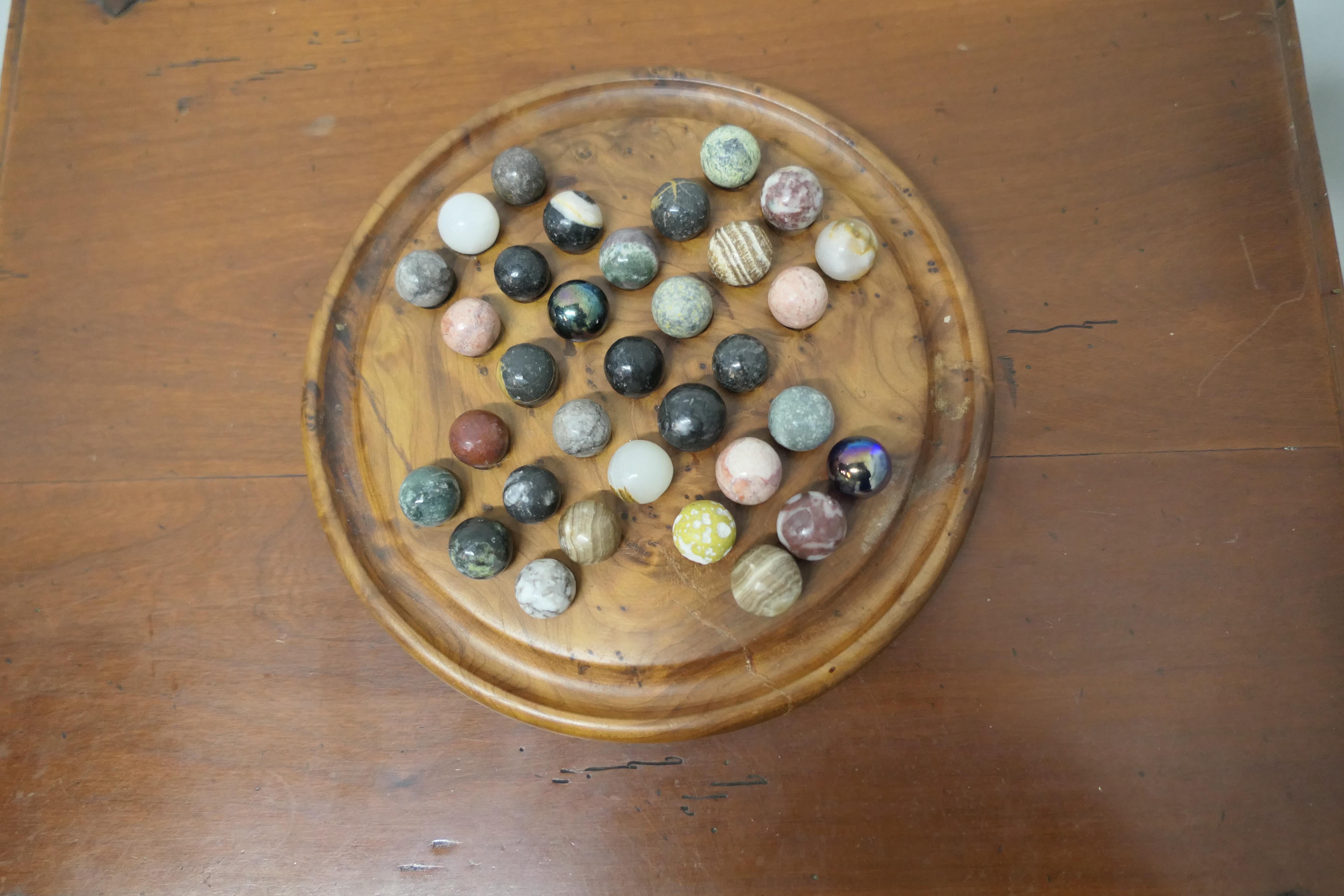 A set of French marbles on a turned solitaire board.

This is a great collection, there are 33 marbles, made in mostly marble with some other minerals, they are set on a beautiful turned a yew wood board.

All in all a very attractive set, the