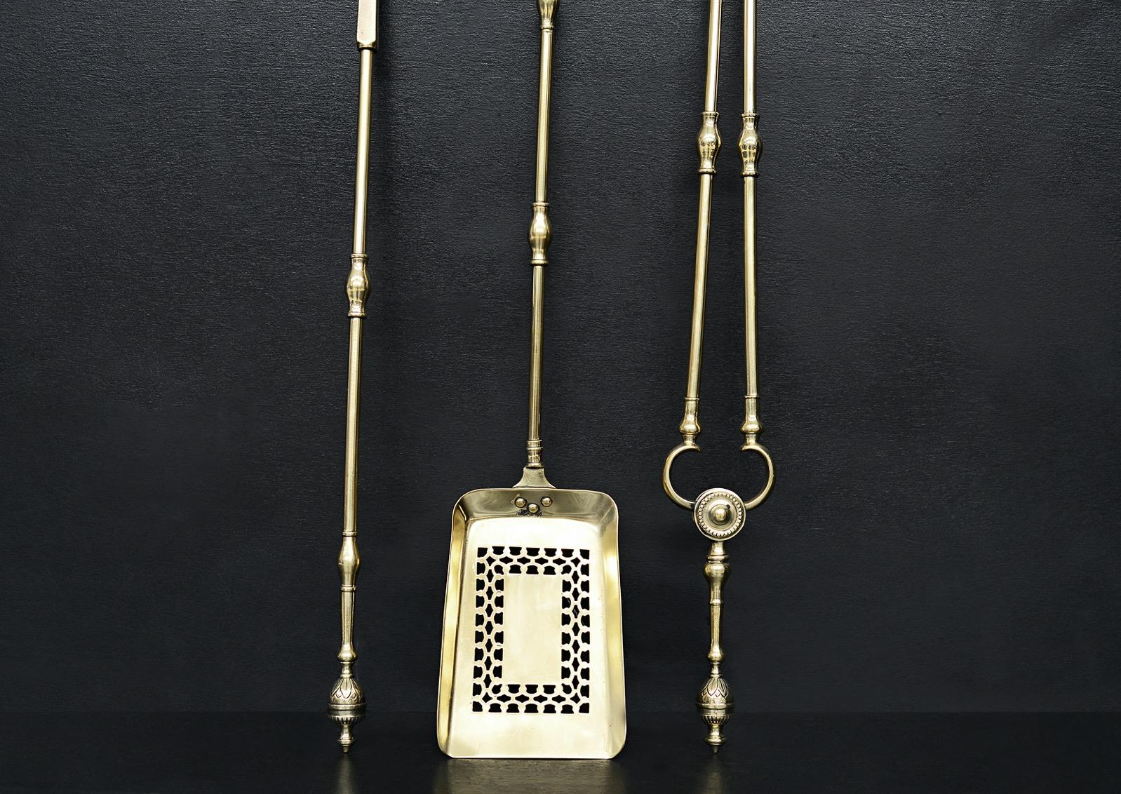 A set of Georgian polished brass firetools. The rectangular pan pierced with diamond motif, the shafts with swells to centre and engraved urn finials. English, 19th century. Good quality.

Length:	770 mm      	30 ⅜